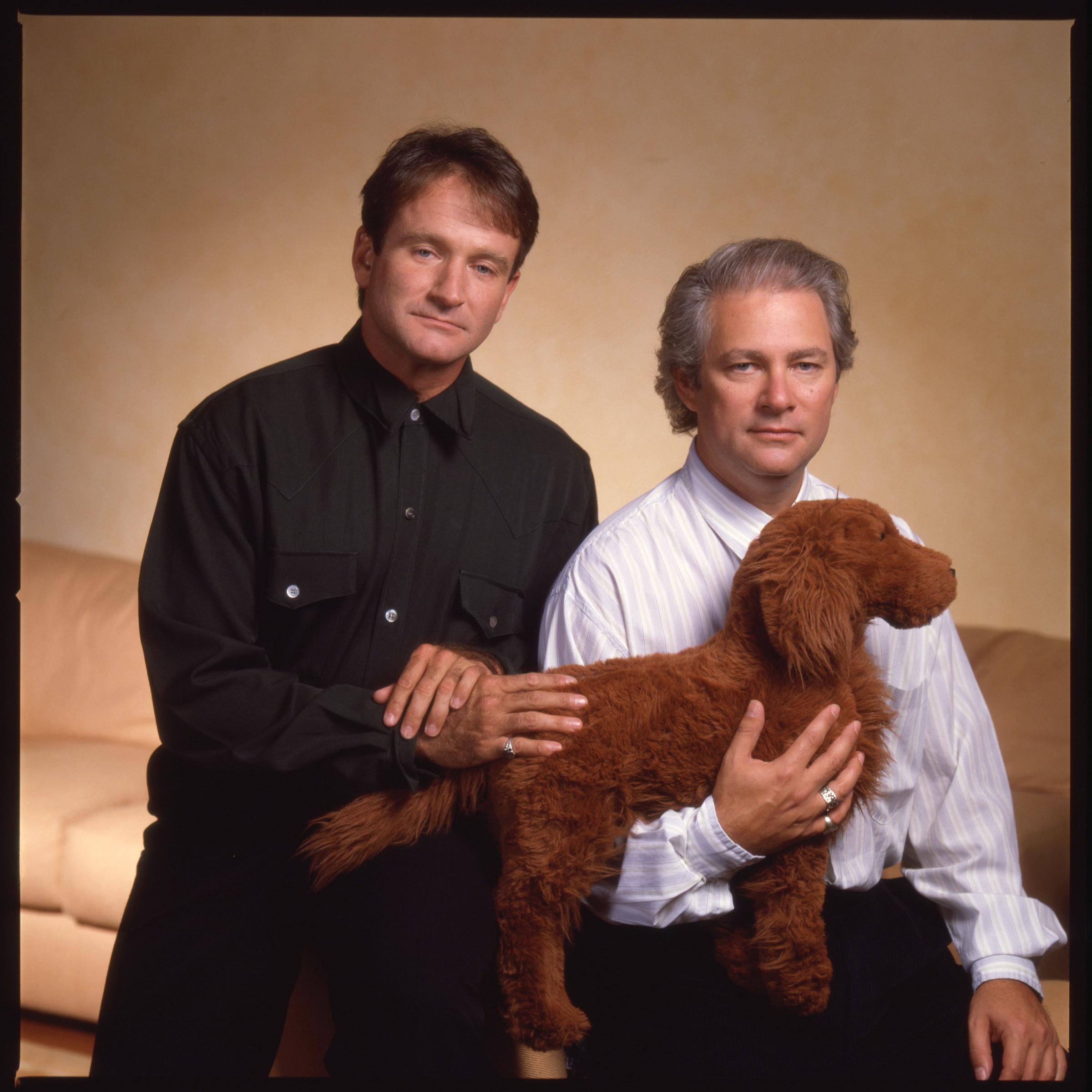 Robin Williams and director Barry Levinson posing with Levinson's dog, circa 1987. | Source: Getty Images