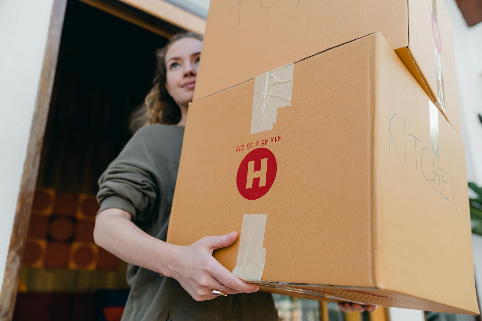 A young woman carrying carton boxes | Source: Pexels
