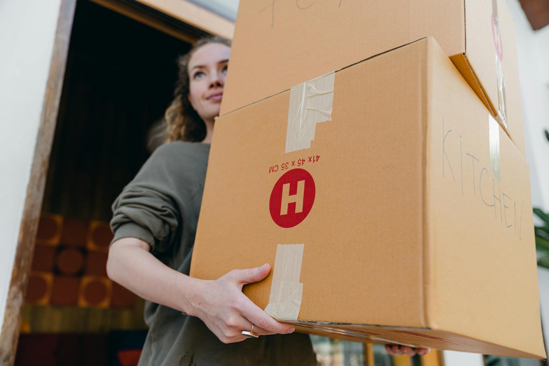 Una mujer joven que llevaba cajas de cartón | Fuente: Pexels