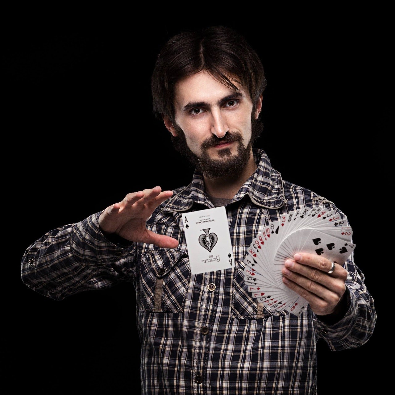 Man performing a card trick | Photo: Pexels