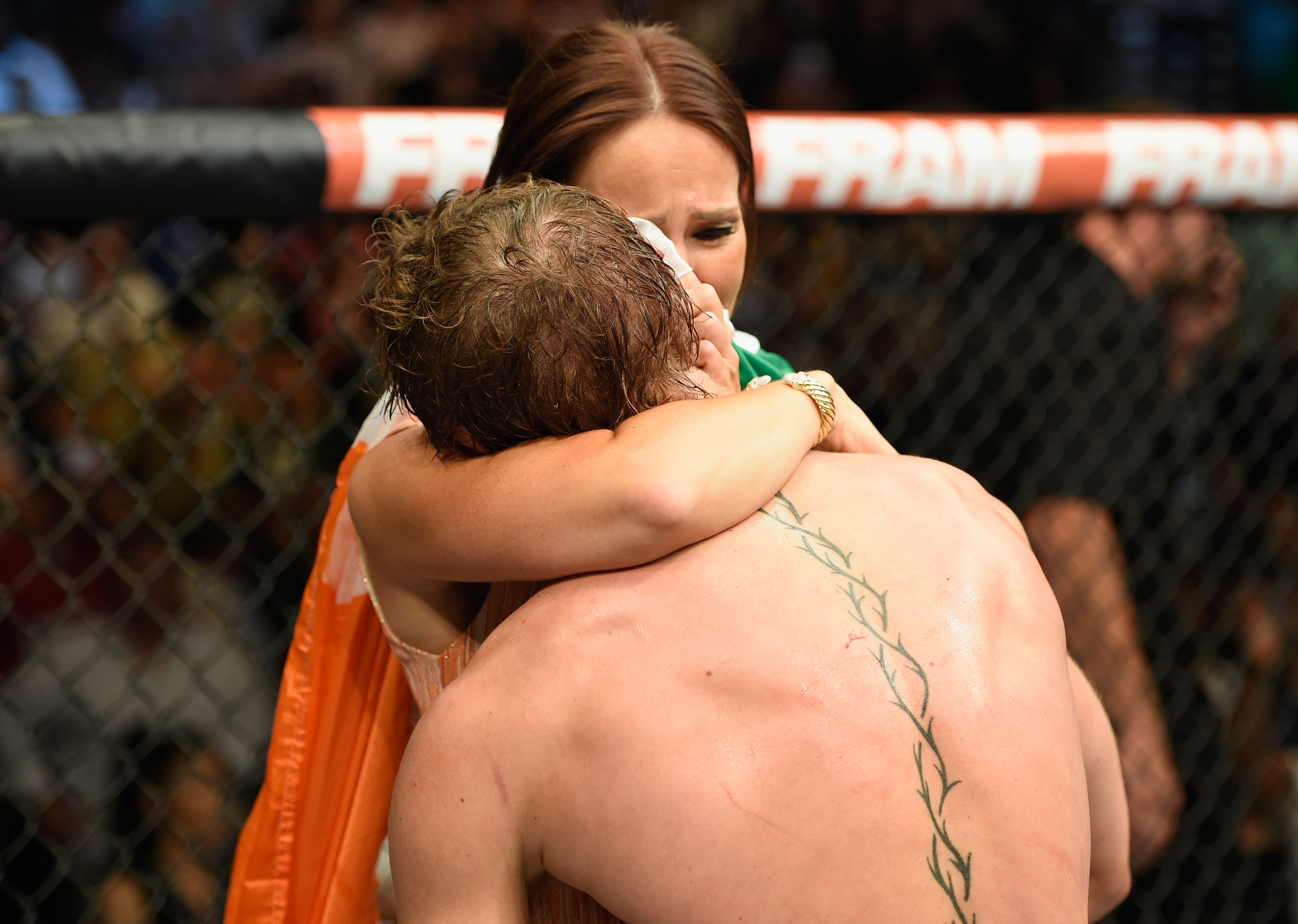 Conor McGregor and Dee Devlin hugging after his UFC interim featherweight title fight during the UFC 189 event inside MGM Grand Garden Arena on July 11, 2015, in Las Vegas, Nevada. | Source: Getty Images