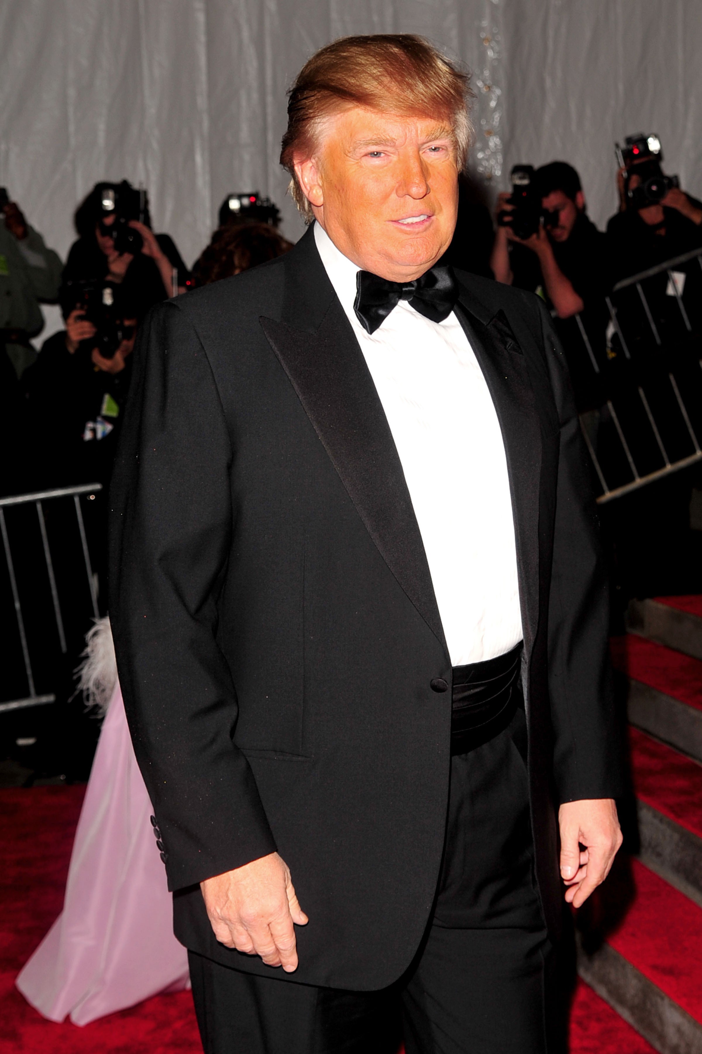 Donald arrived at the 2009 Costume Institute Gala dressed in a classic black tuxedo paired with a crisp white shirt and a black bow tie. His signature blond hair was styled in its usual swept-front fashion, and a subtle smile played on his face as he posed for the cameras.