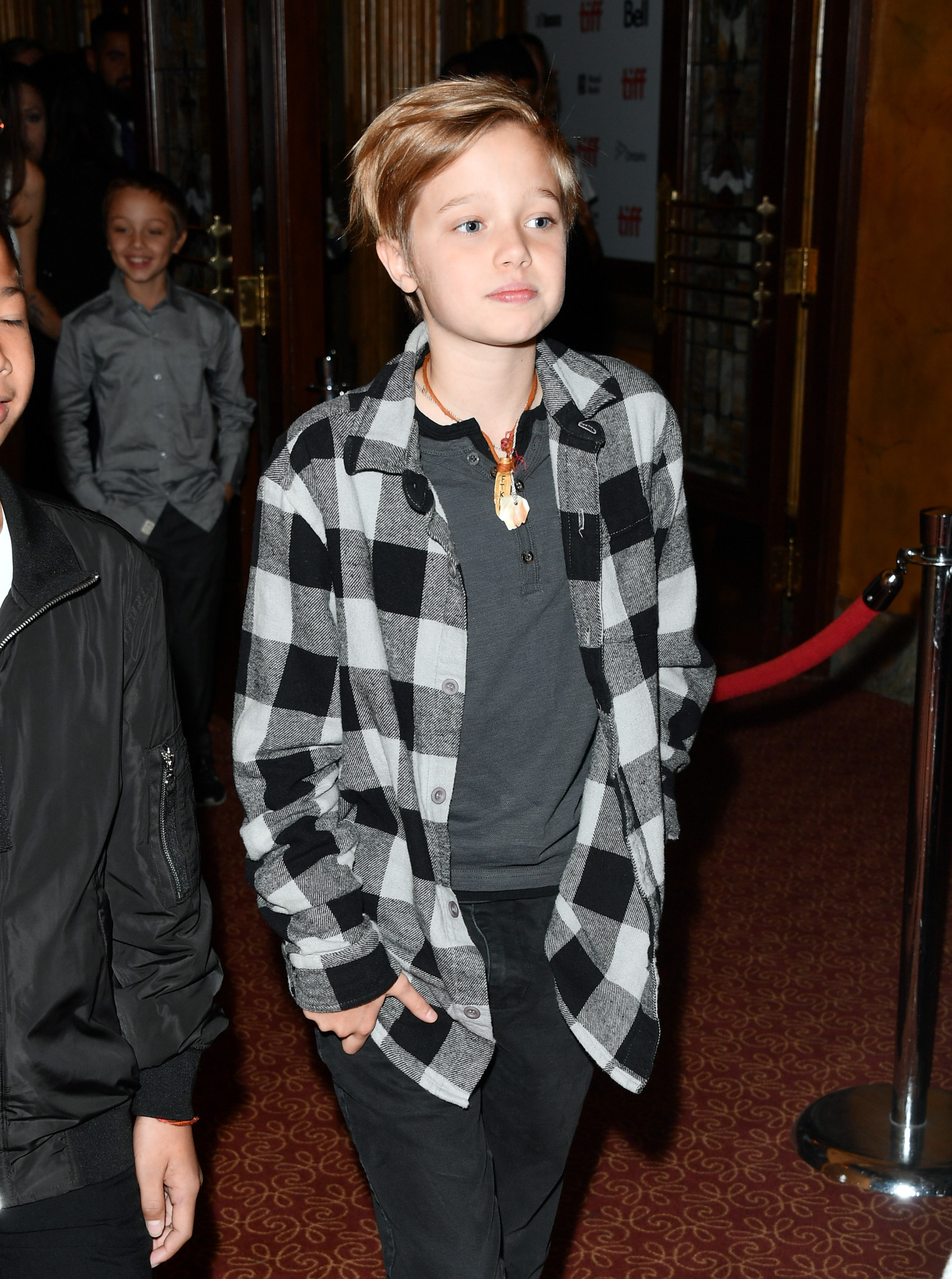 Shiloh Jolie-Pitt attends "The Breadwinner" premiere in Toronto with a relaxed, confident presence. Wearing a plaid shirt over a dark tee, her style feels effortless yet intentional. The look hints at a subtle shift as her personal style continues to evolve.