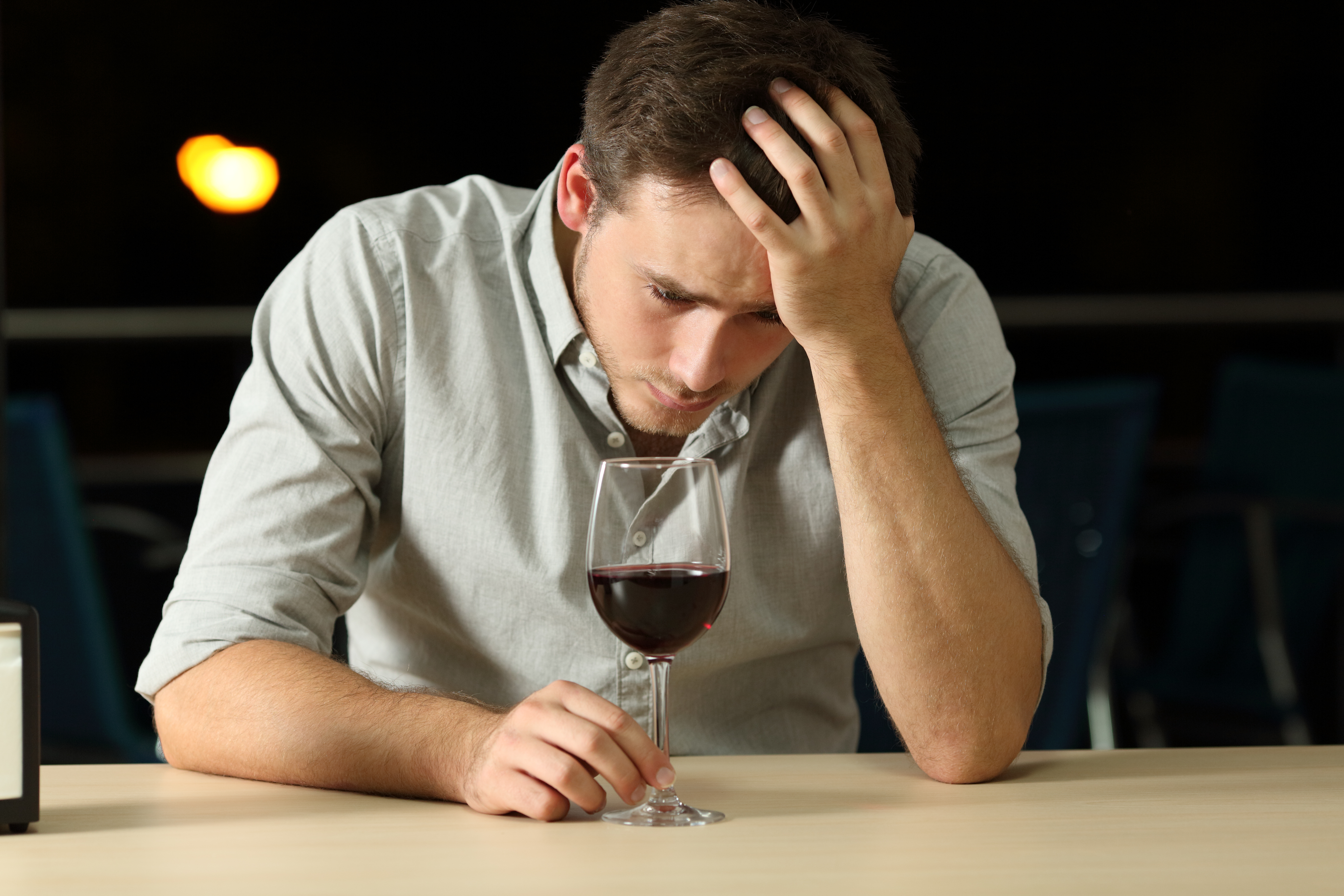 Sad man sitting alone with a drink | Source: Shutterstock