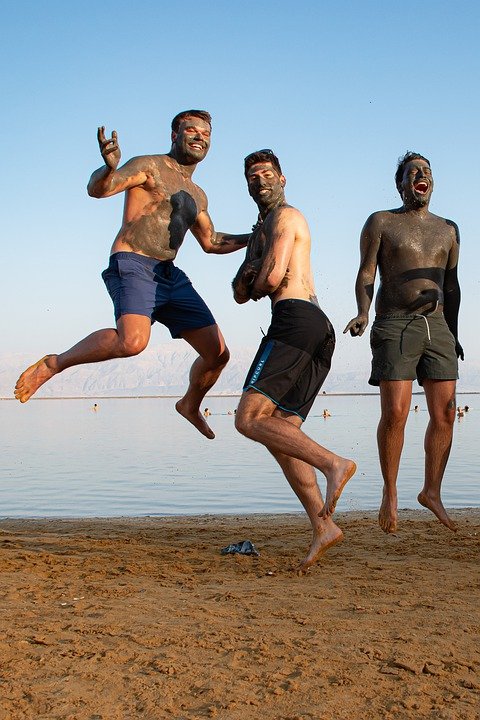 Three men having fun together at a beach | Photo: Pixabay
