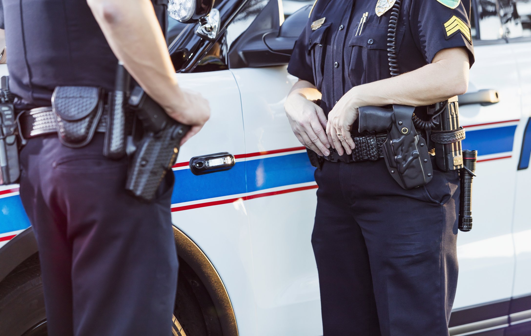 Two policemen having a chat by their patrol cars | Photo: Pexels