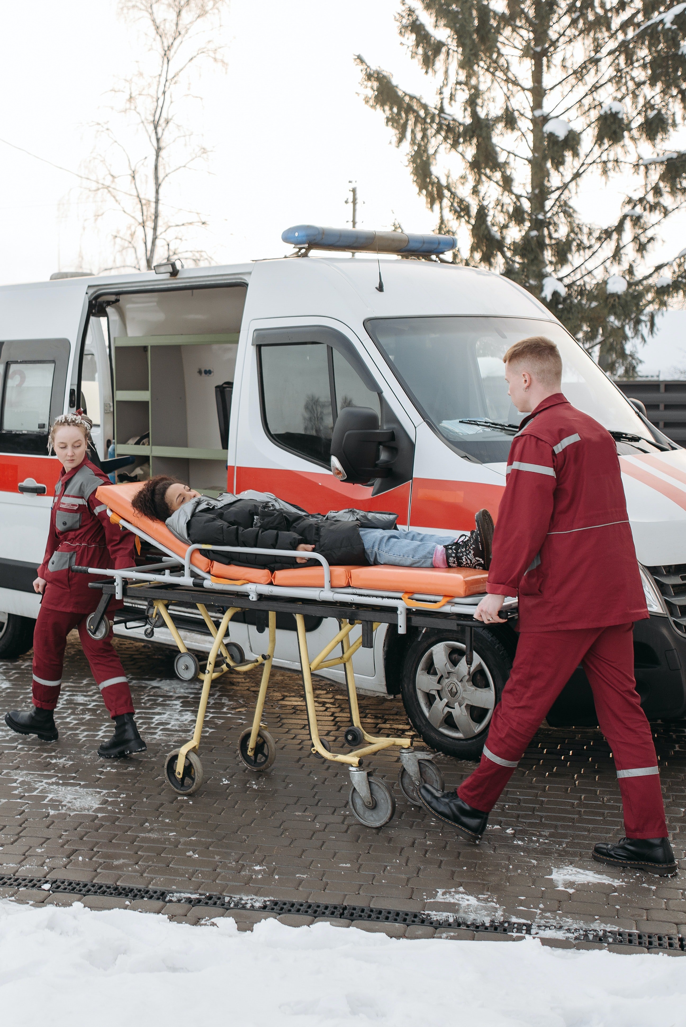 Los paramédicos llevan a una mujer en camilla hacia la ambulancia. | Foto: Pexels