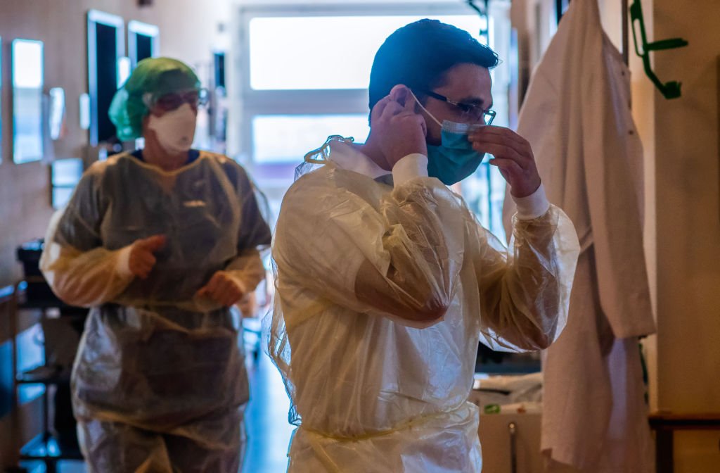 Médicos  usan trajes protectores, anteojos y tapabocas. | Foto de Jens Büttner a través de Getty Images