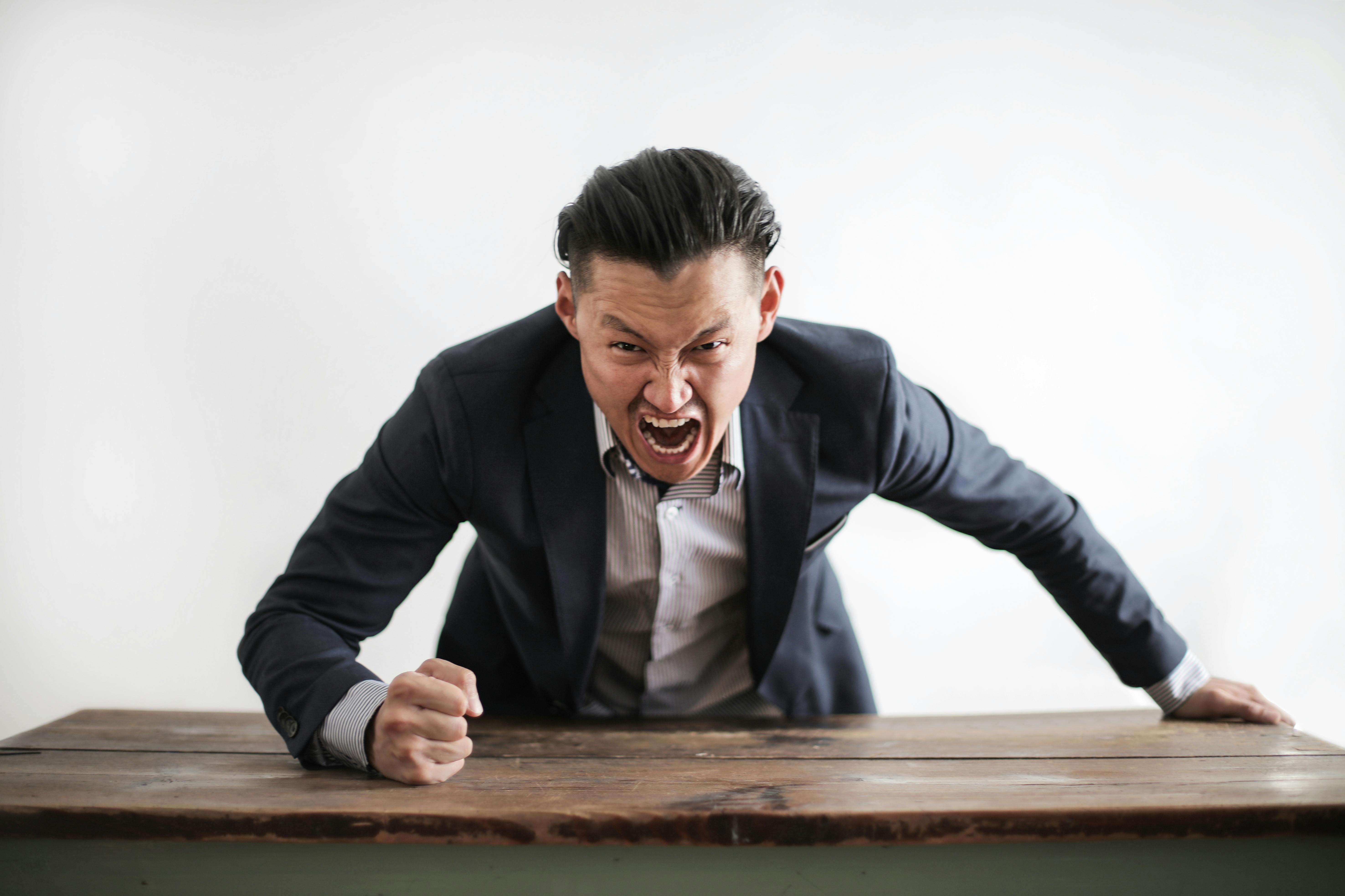 An angry man screaming over a table | Source: Pexels