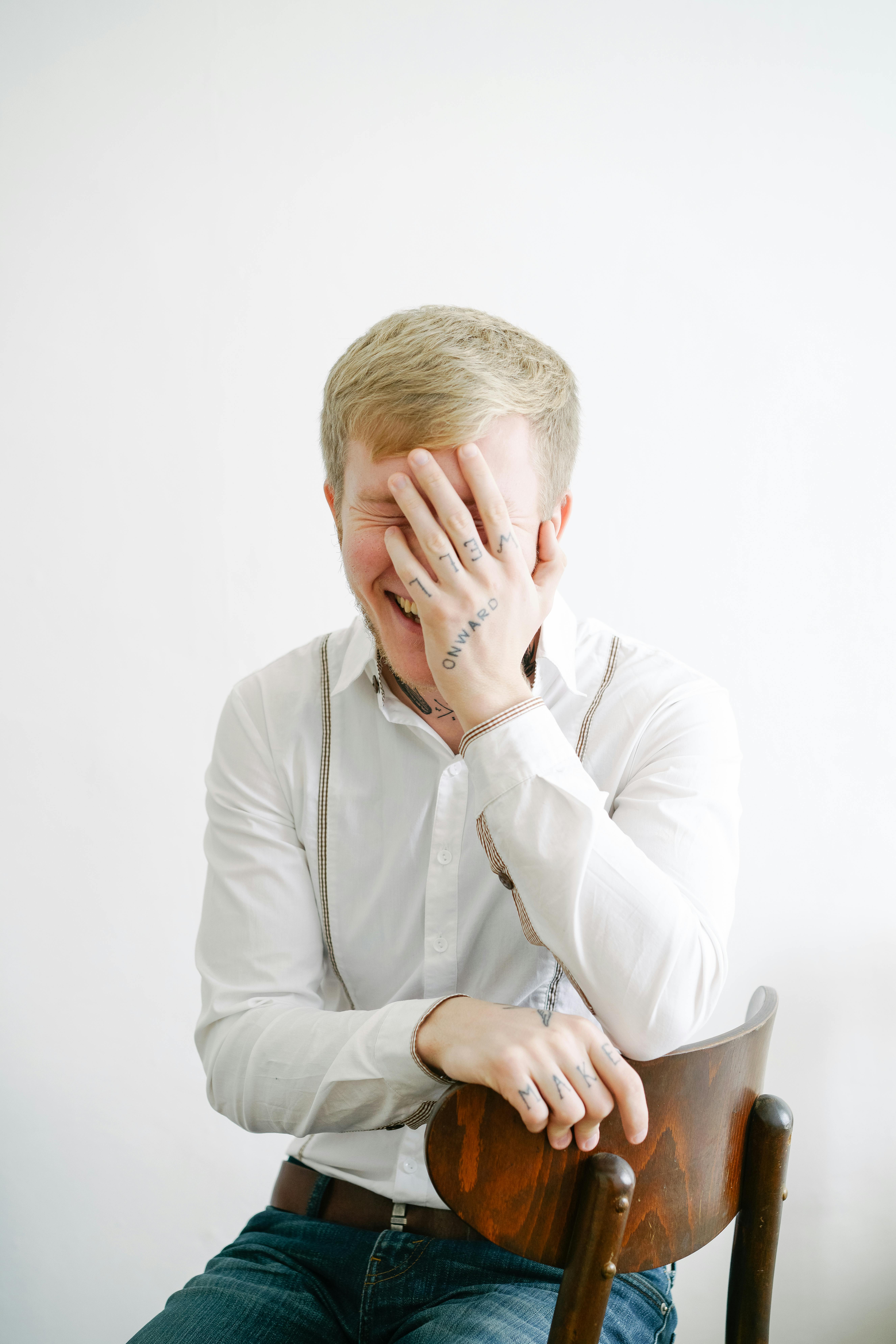 A man sitting in a chair laughing | Source: Pexels