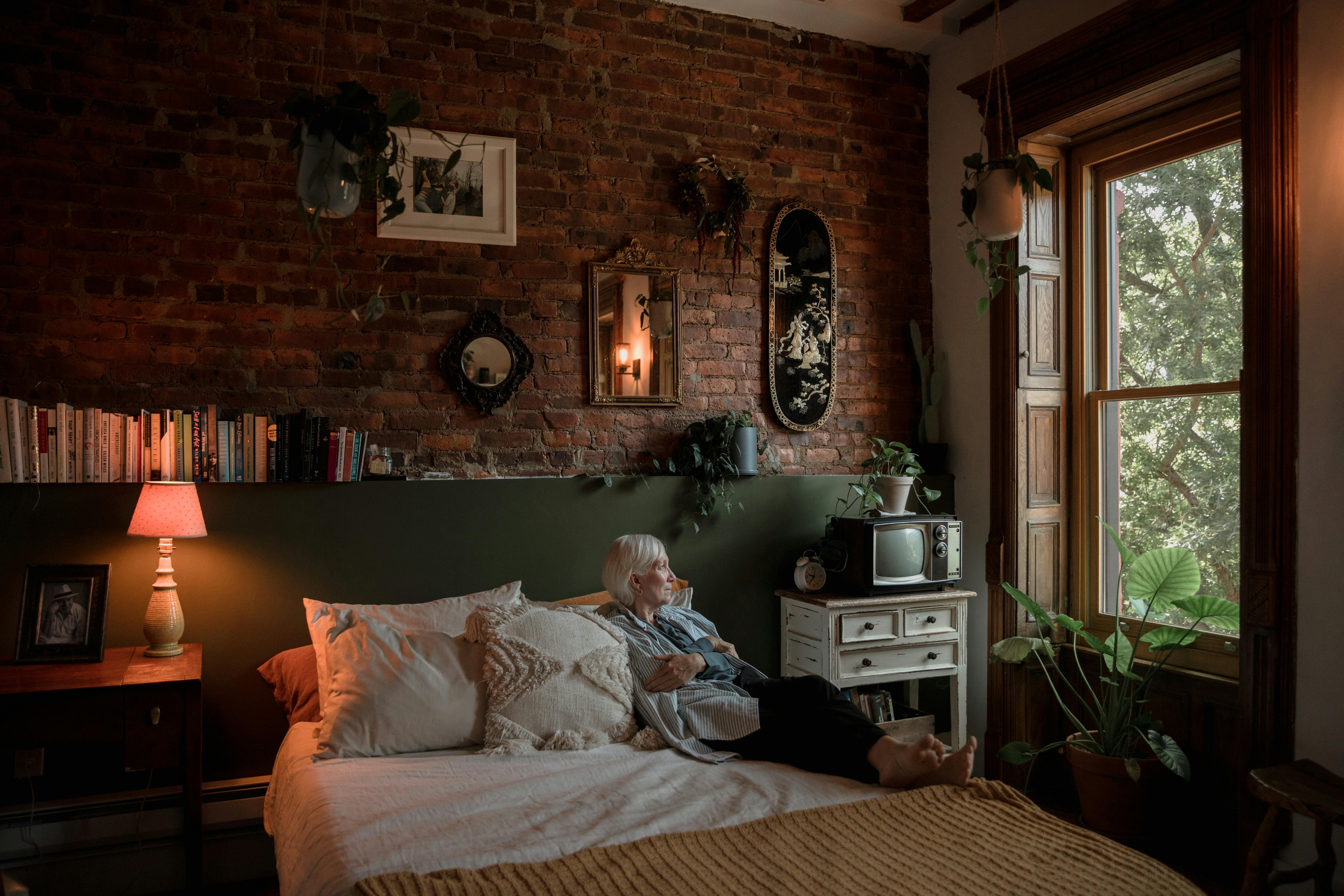 Elderly woman sitting on bed | Source: Pexels