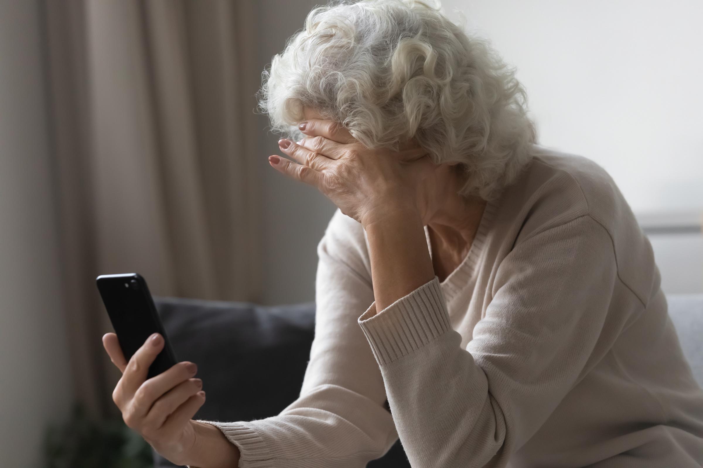 Stressed senior woman looking at her phone | Source: Shutterstock