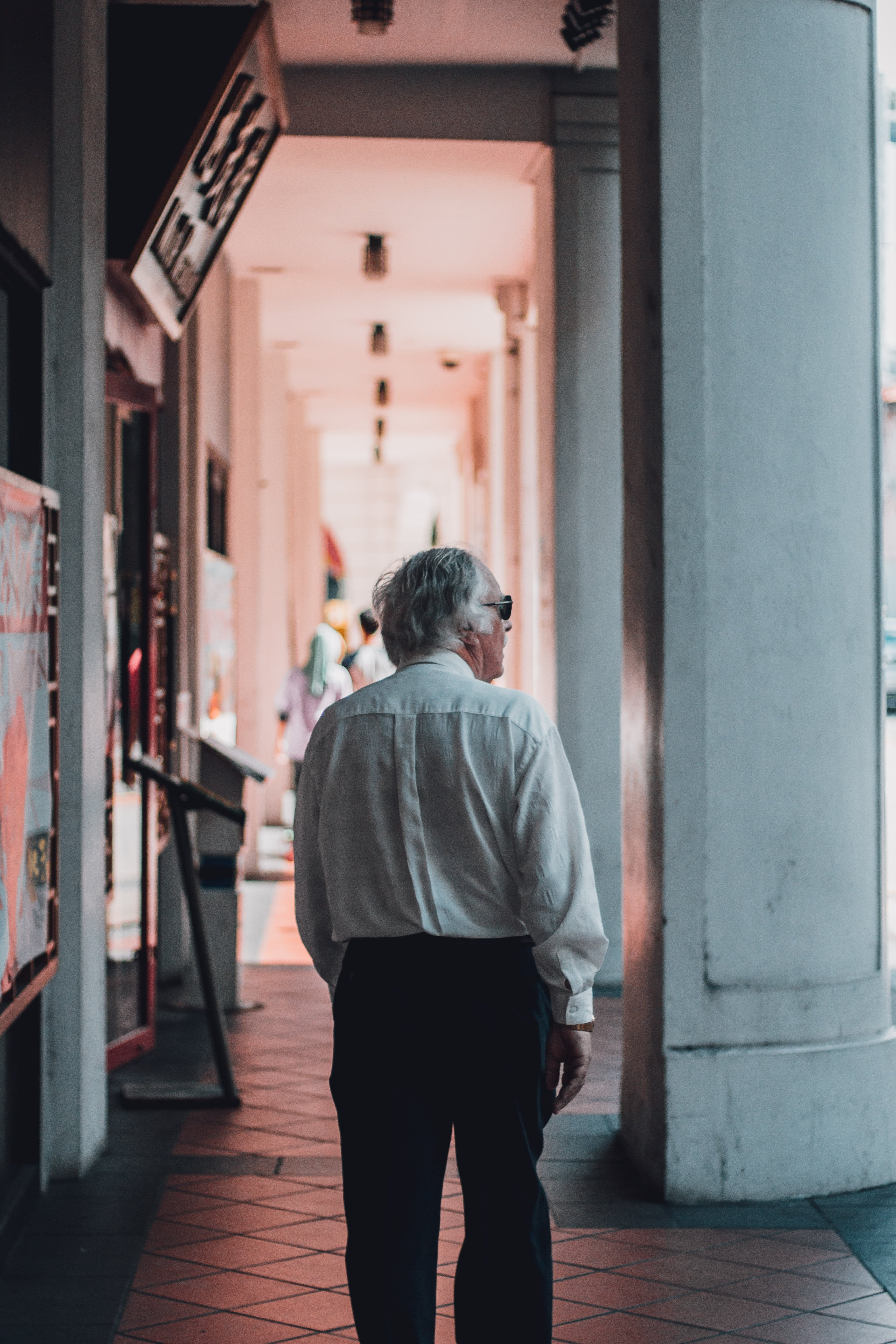Old man walking through college corridors  | Photo by Lily Banse on Unsplash