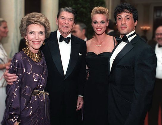 President and Nancy Reagan posing with Sylvester Stallone and Brigitte Nielsen during a state dinner for Prime Minister Lee Kuan Yew of Singapore. | Source: Wikimedia Commons