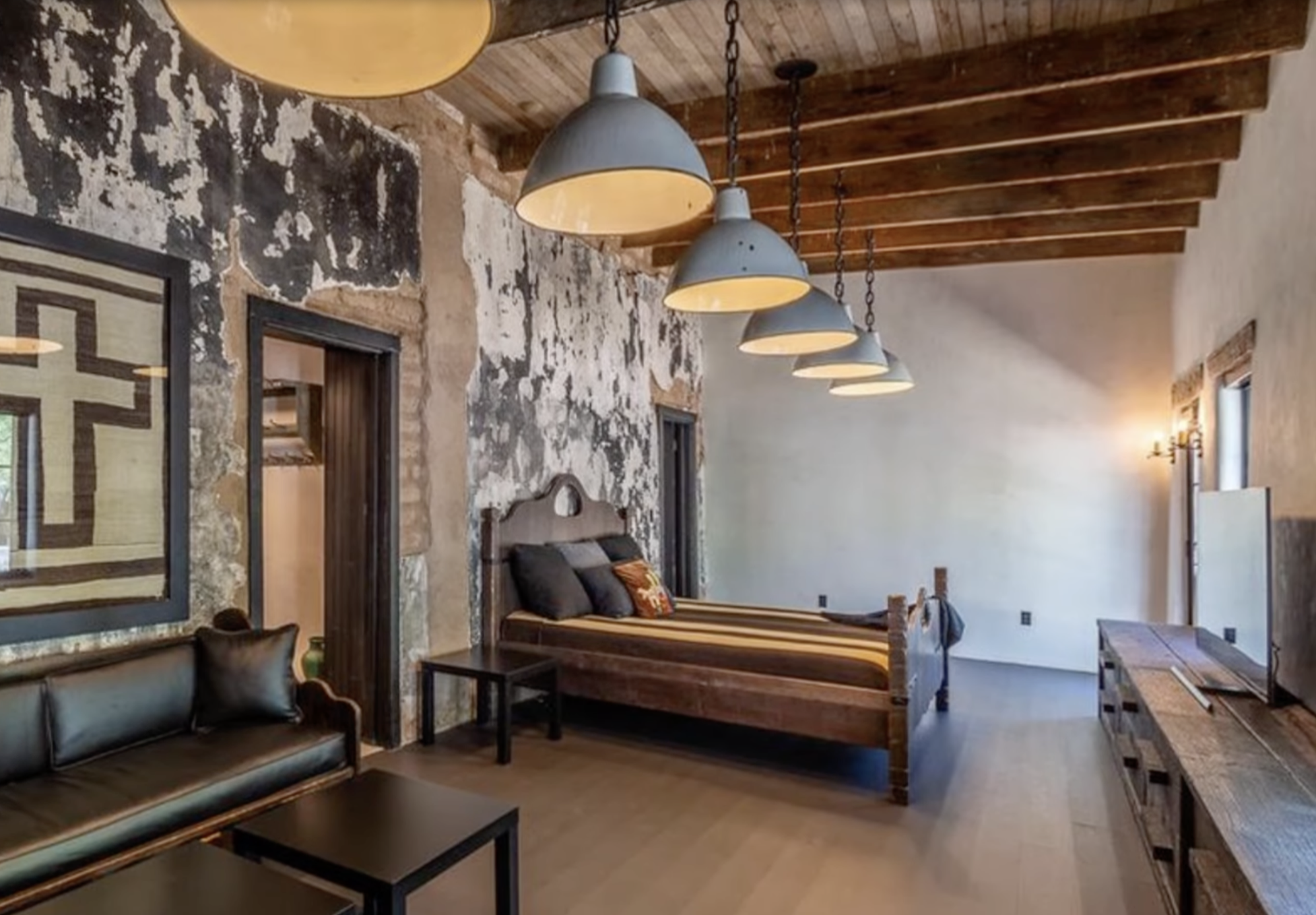Rustic bedroom with exposed ceiling beams and distressed walls inside Diane Keaton’s Sullivan Canyon home, dated February 3, 2022 | Source: YouTube/@FamousEntertainment500k