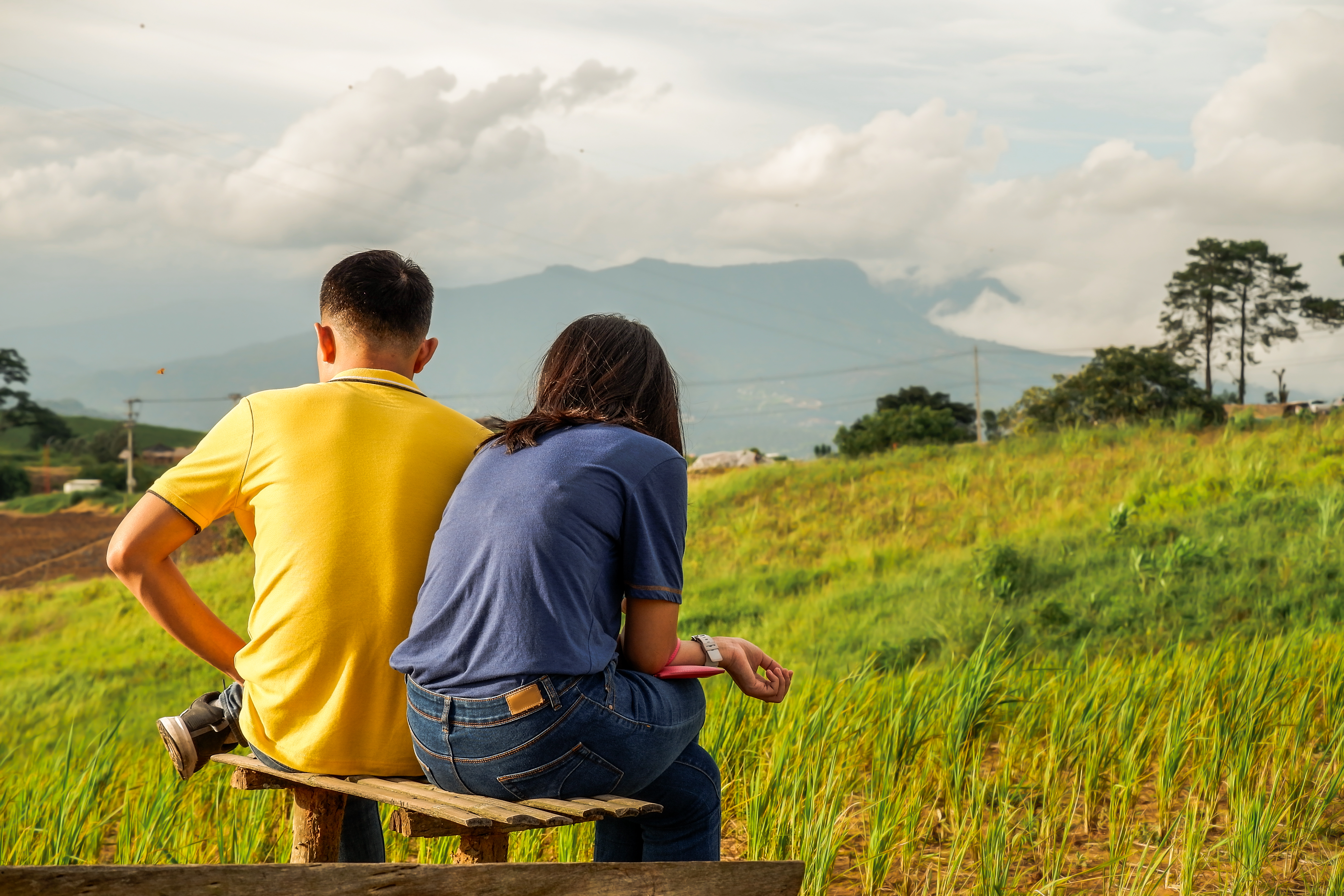 Couple sitting on a bench outside. | Source: Shutterstock