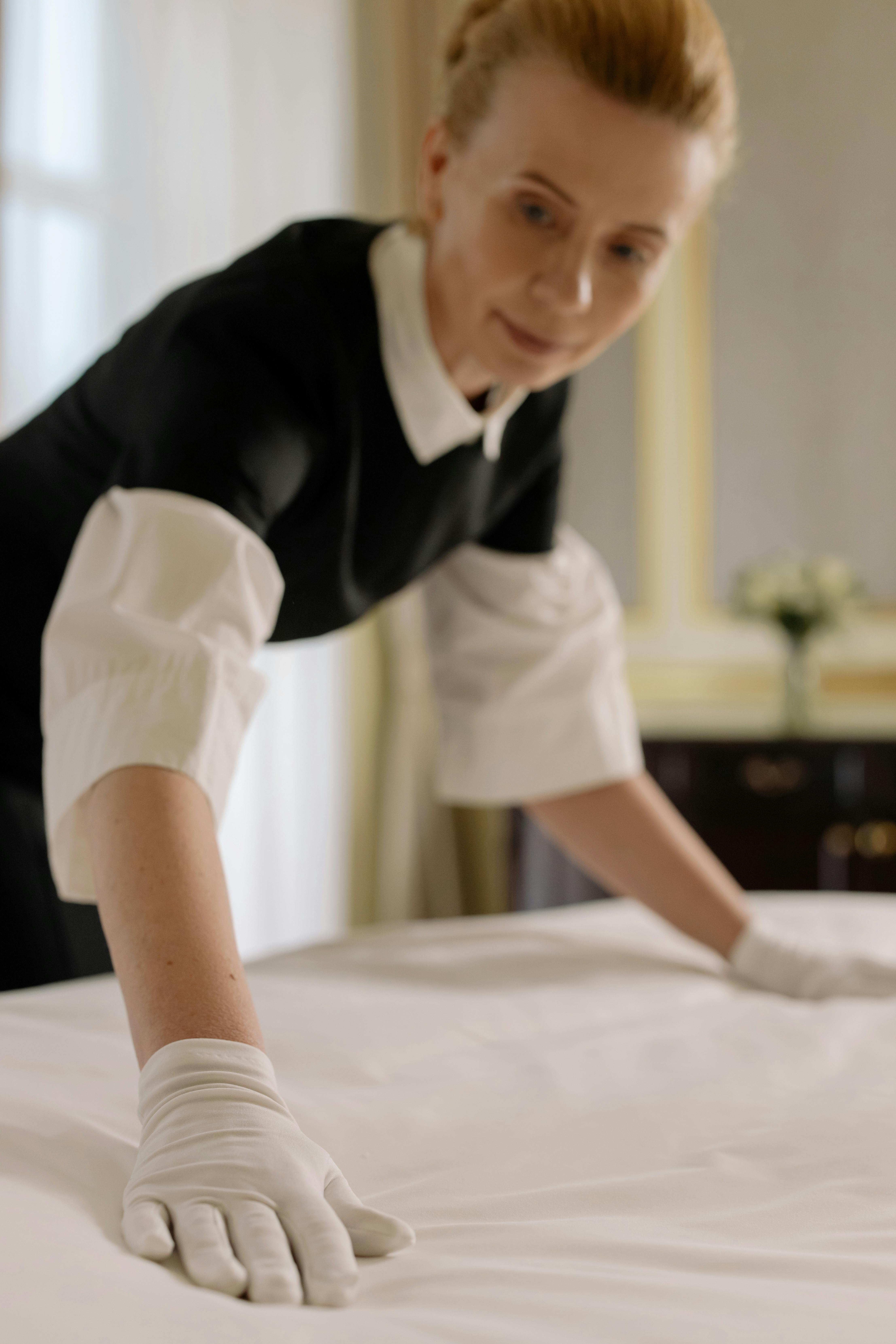 Woman tiding up a hotel room | Source: Pexels