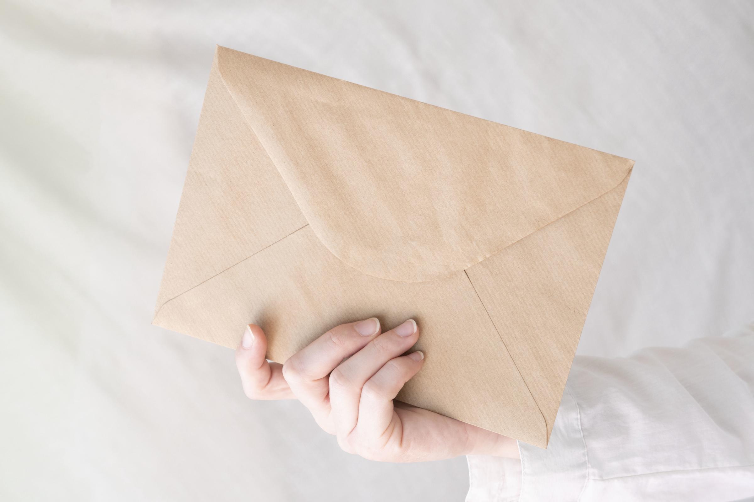 Lori hands Christina an envelope | Source: Freepik