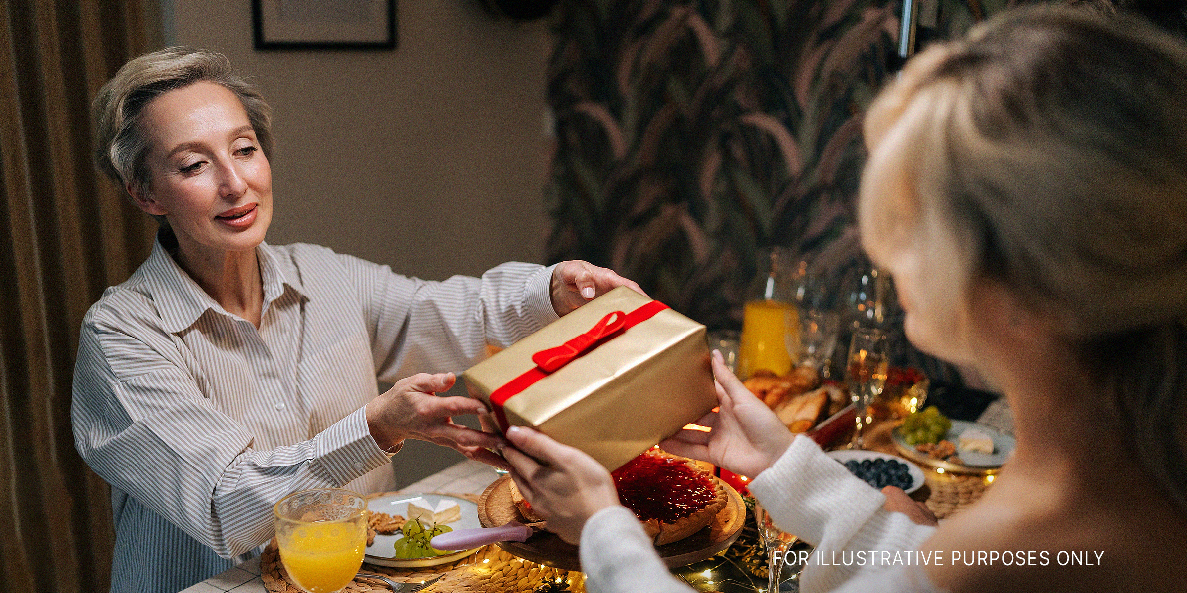 Woman hands over a present | Source: Shutterstock