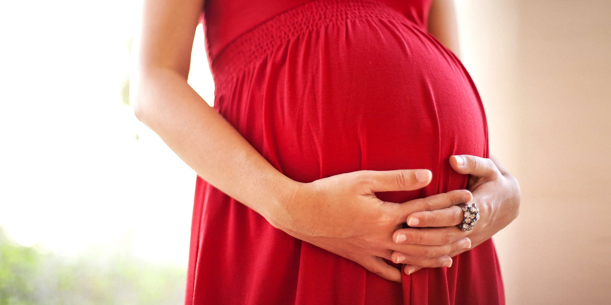 Pregnant woman holding her stomach | Source: Shutterstock