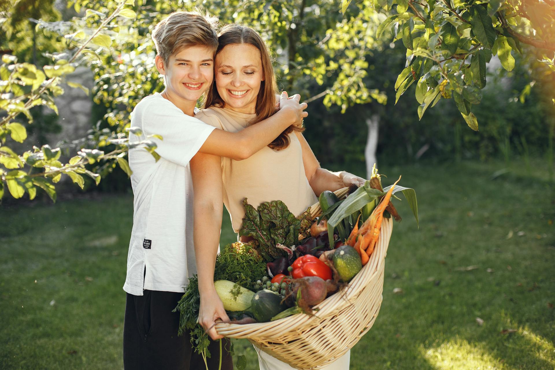 A boy hugging his mom in the garden | Source: Pexels