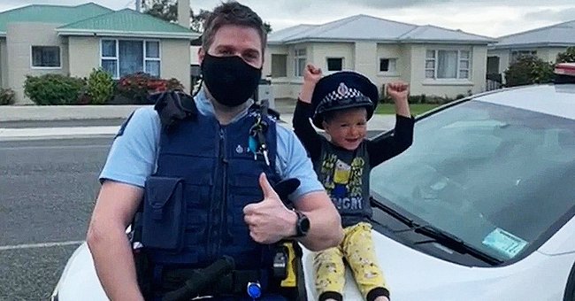 A four-year-old smiles with Constable Kurt on a police patrol. | Source: youtube.com/New Zealand Police 