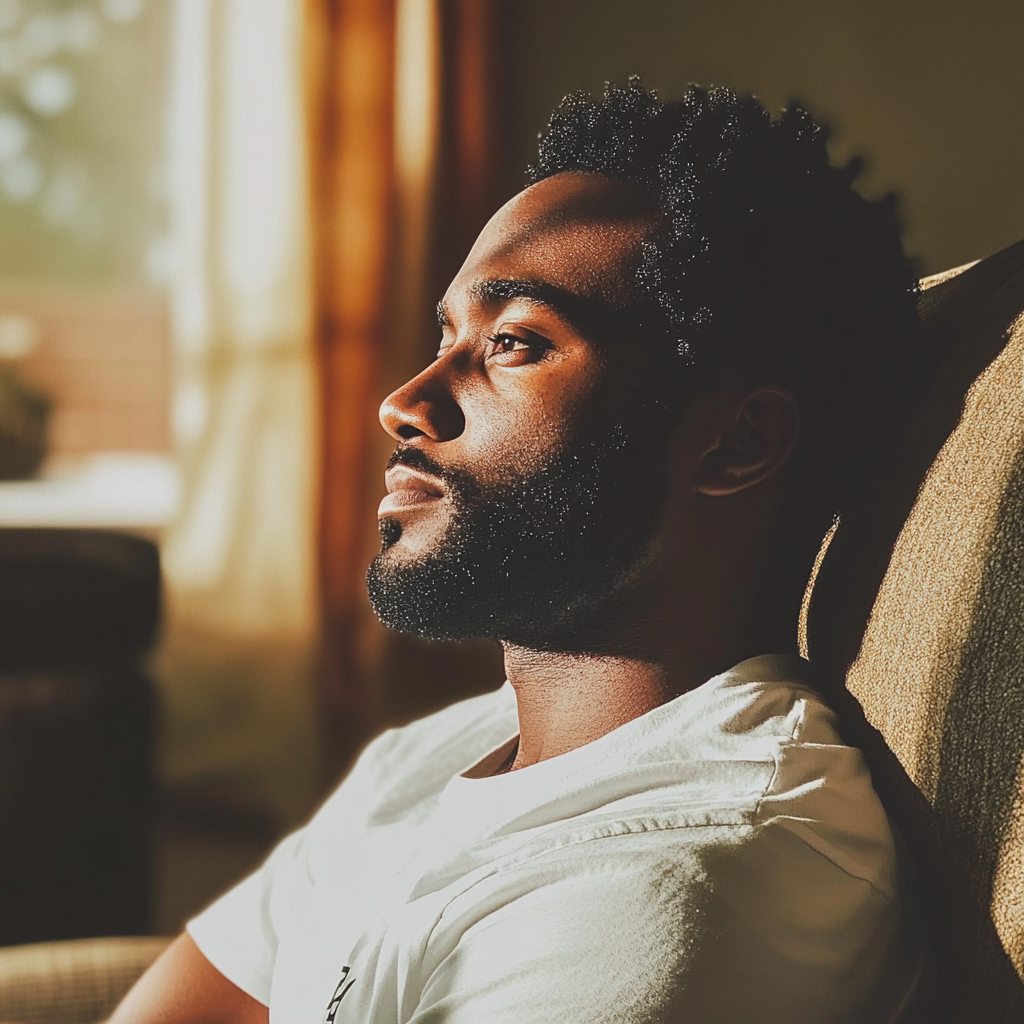 A pensive man sitting on a couch | Source: Midjourney