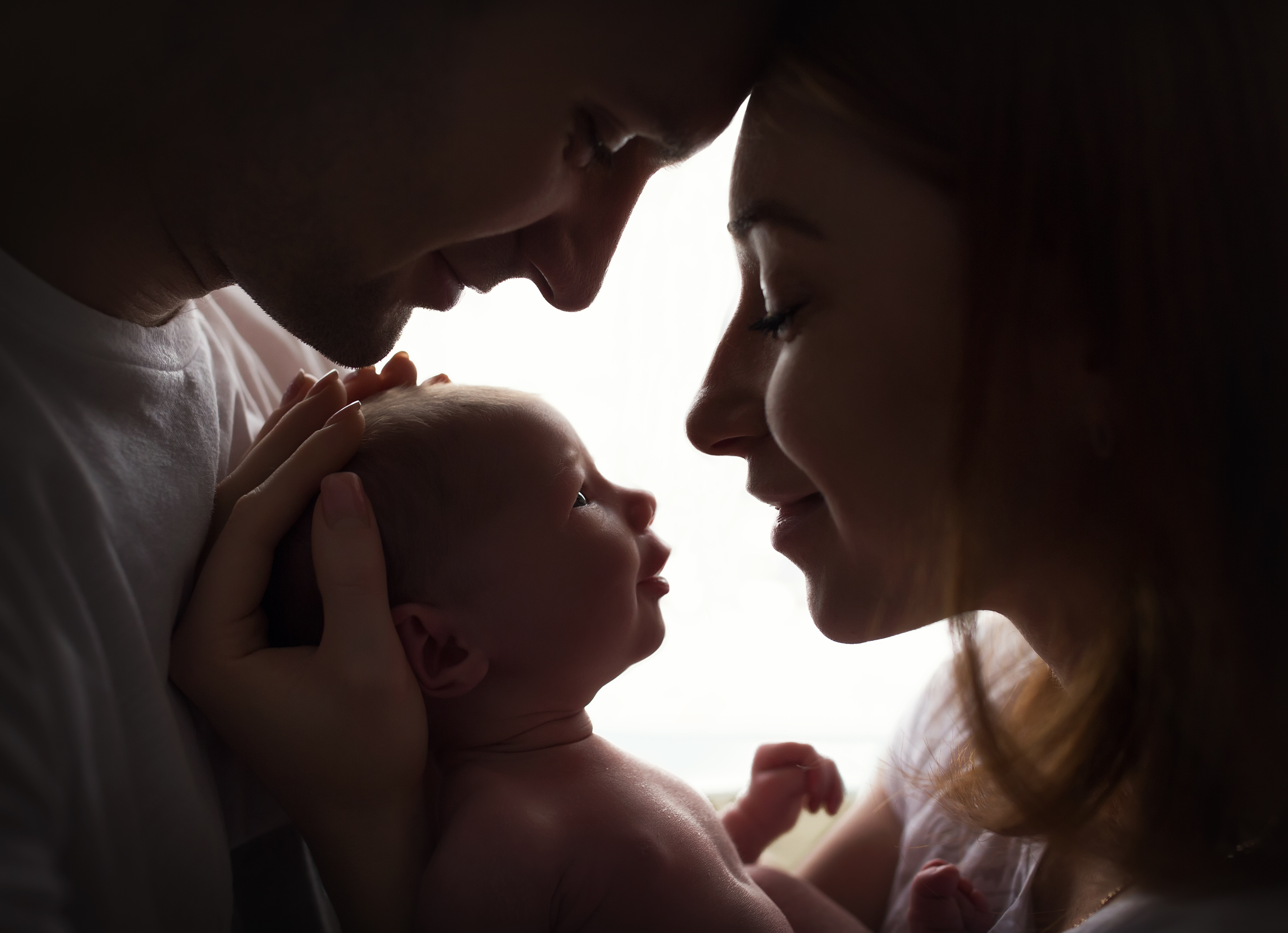 Eine Silhouette glücklicher Eltern mit einem neugeborenen Baby | Quelle: Shutterstock