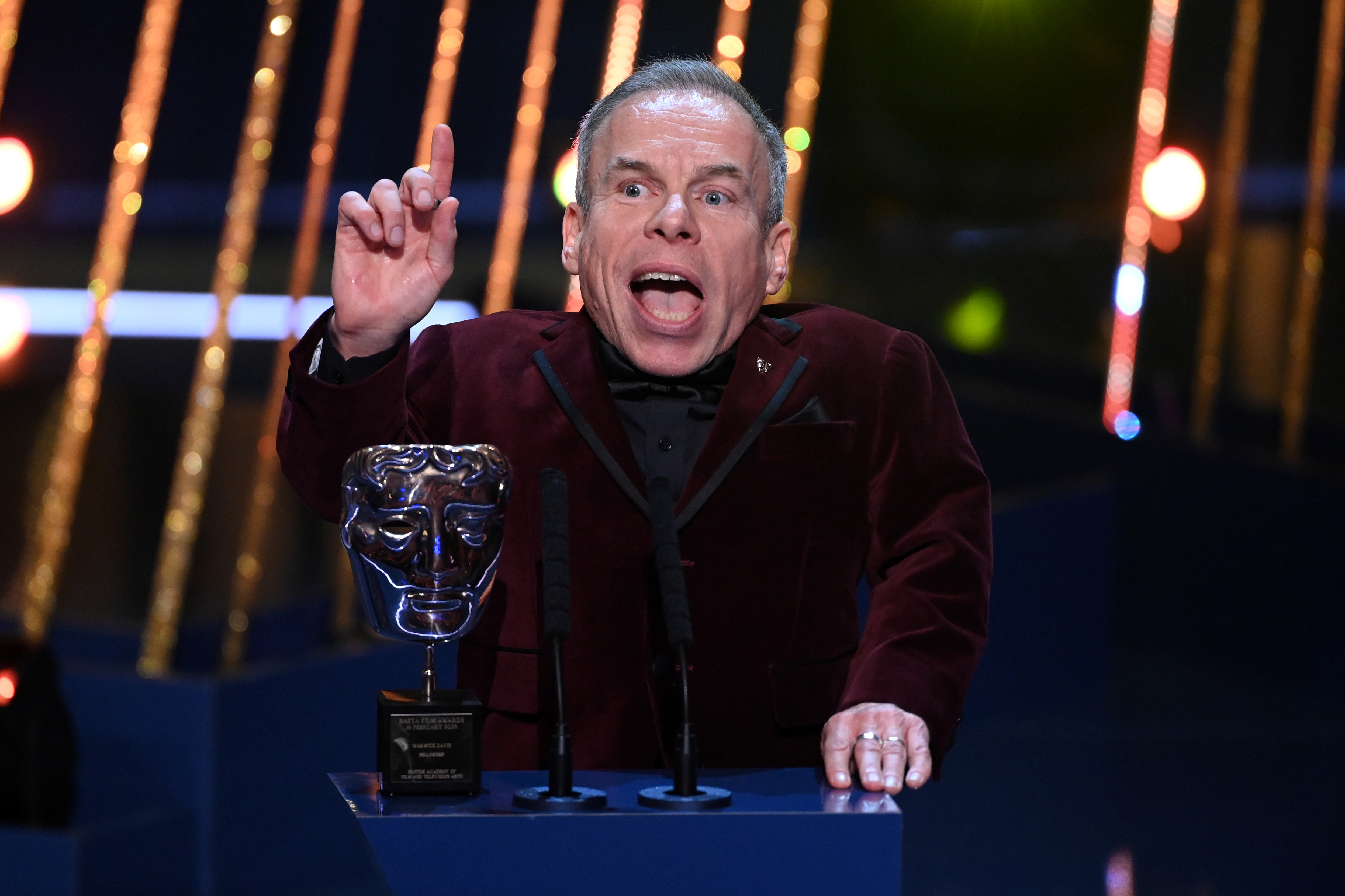 Warwick Davis accepts the Fellowship Award on stage during the EE BAFTA Film Awards 2025 at The Royal Festival Hall on 16 February in London, England. | Source: Getty Images