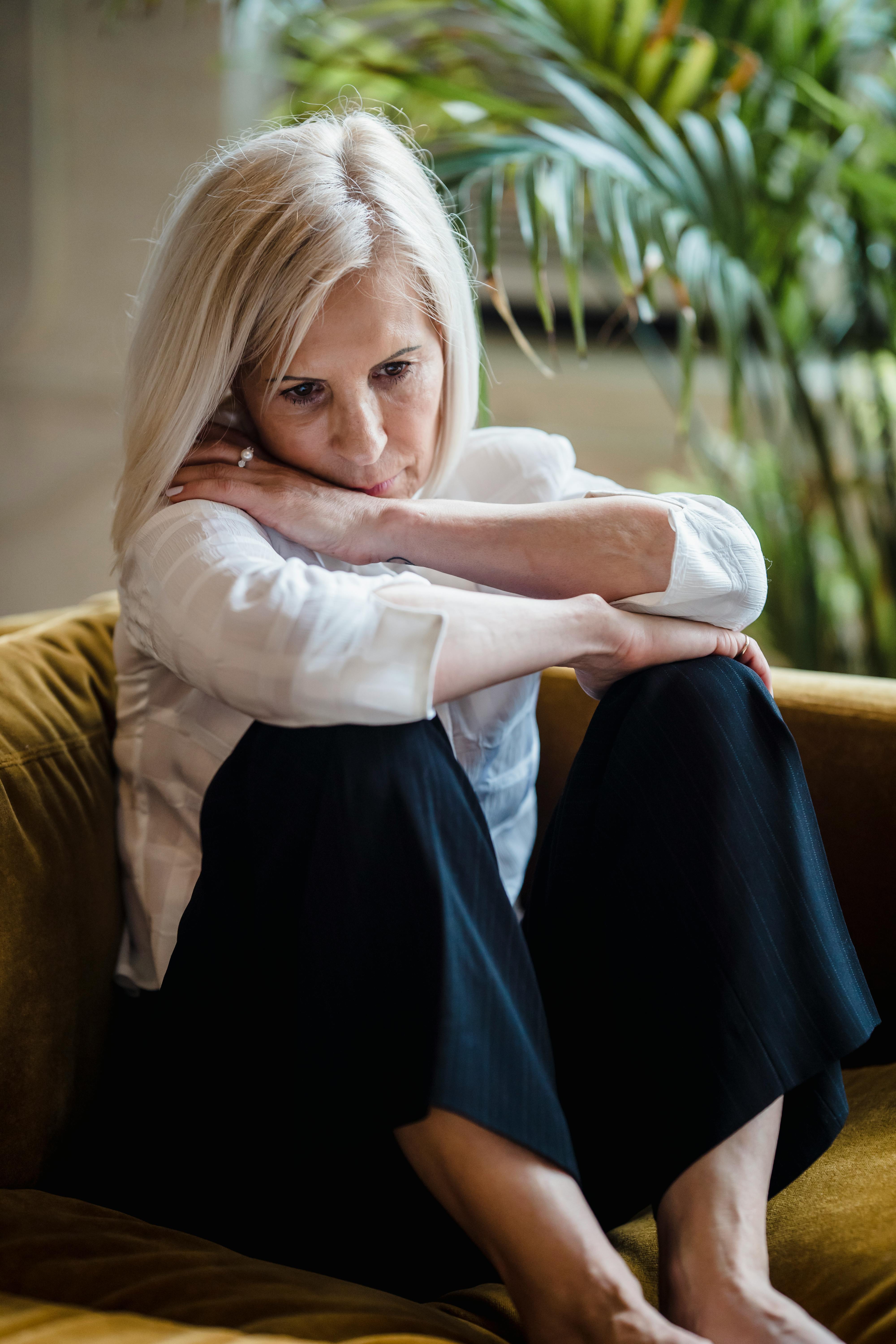 A sad woman sitting on a couch | Source: Pexels