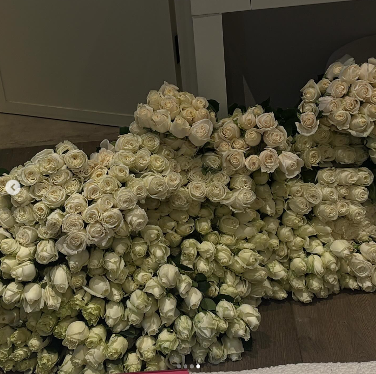 A large arrangement of white roses sits on the floor, posted on February 24, 2025 | Source: Instagram/alabamaluellabarker