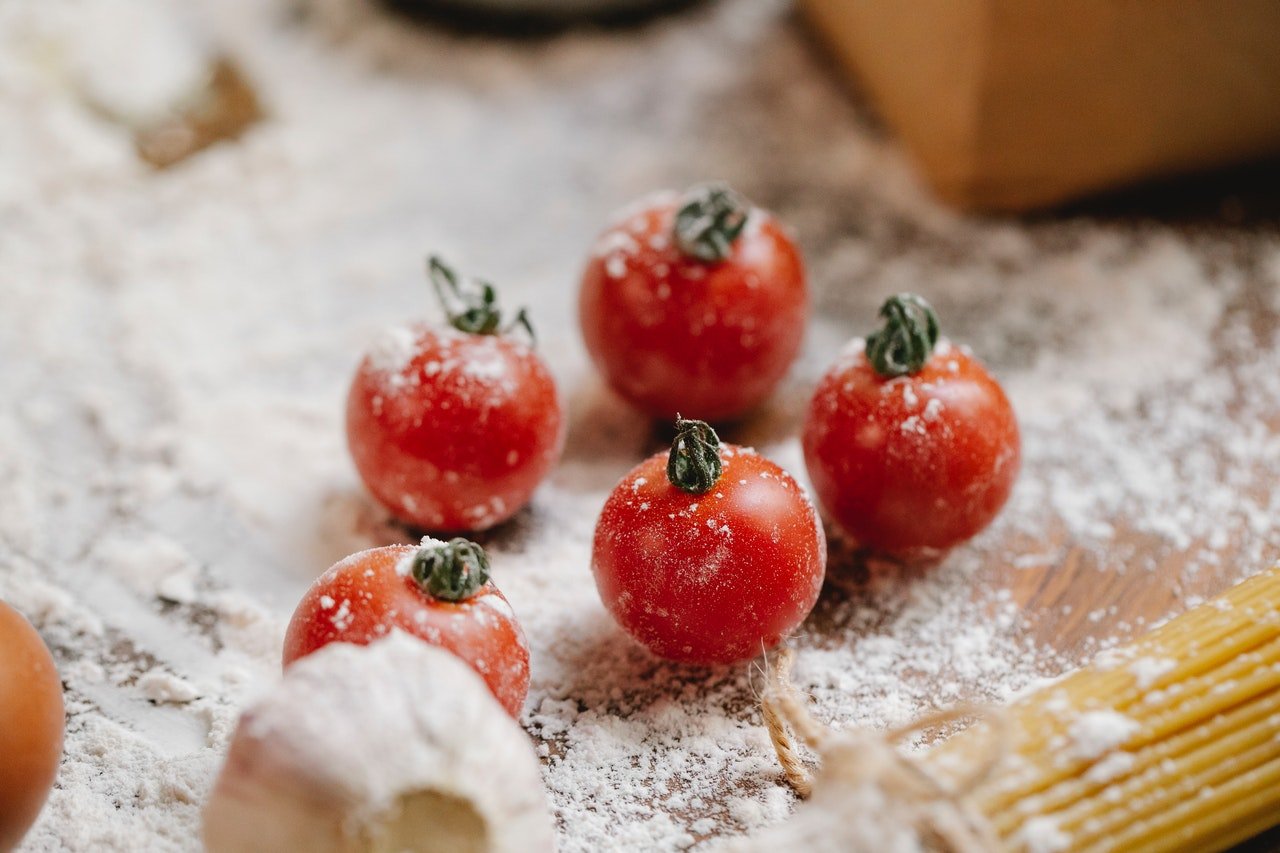 Fresh tomatoes covered with flour | Photo: Pexels