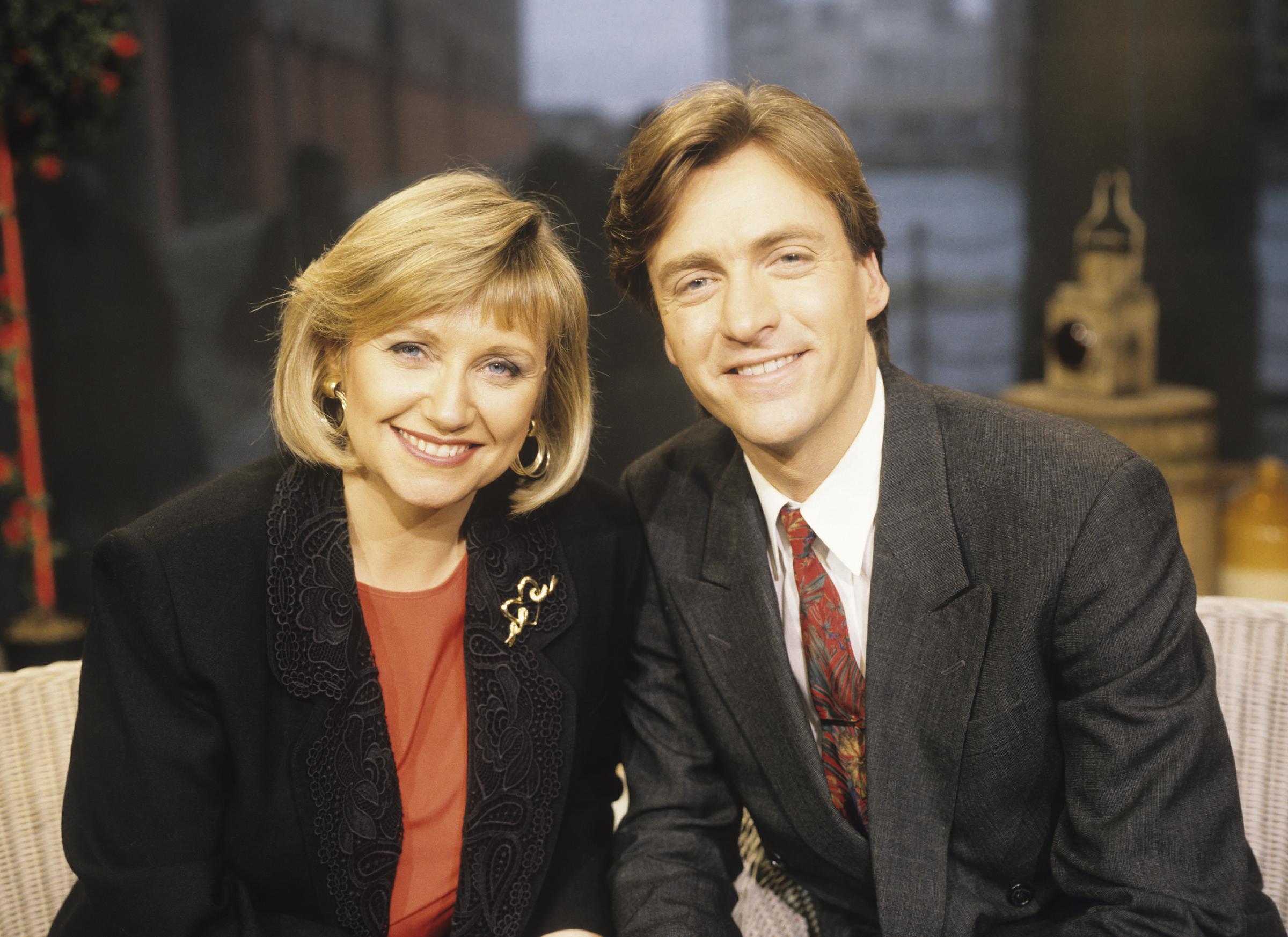 Judy Finnigan and Richard Madeley are pictured in the early years of their television partnership, smiling warmly as they settled into their roles as the original hosts of ITV’s "This Morning" in 1990 — a period that marked the beginning of their rise as one of Britain's most recognisable presenting duos, both on-screen and off.