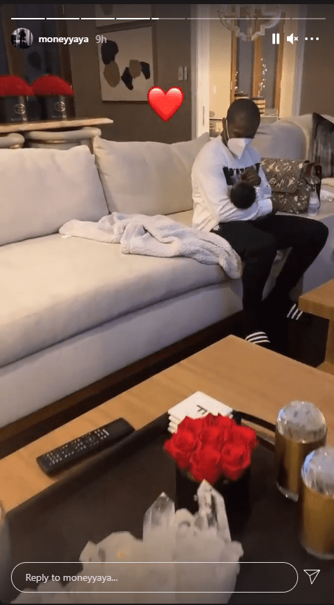 Floyd Mayweather cradling his grandson sitting on a sofa in his home. | Photo: Instagram/moneyyaya