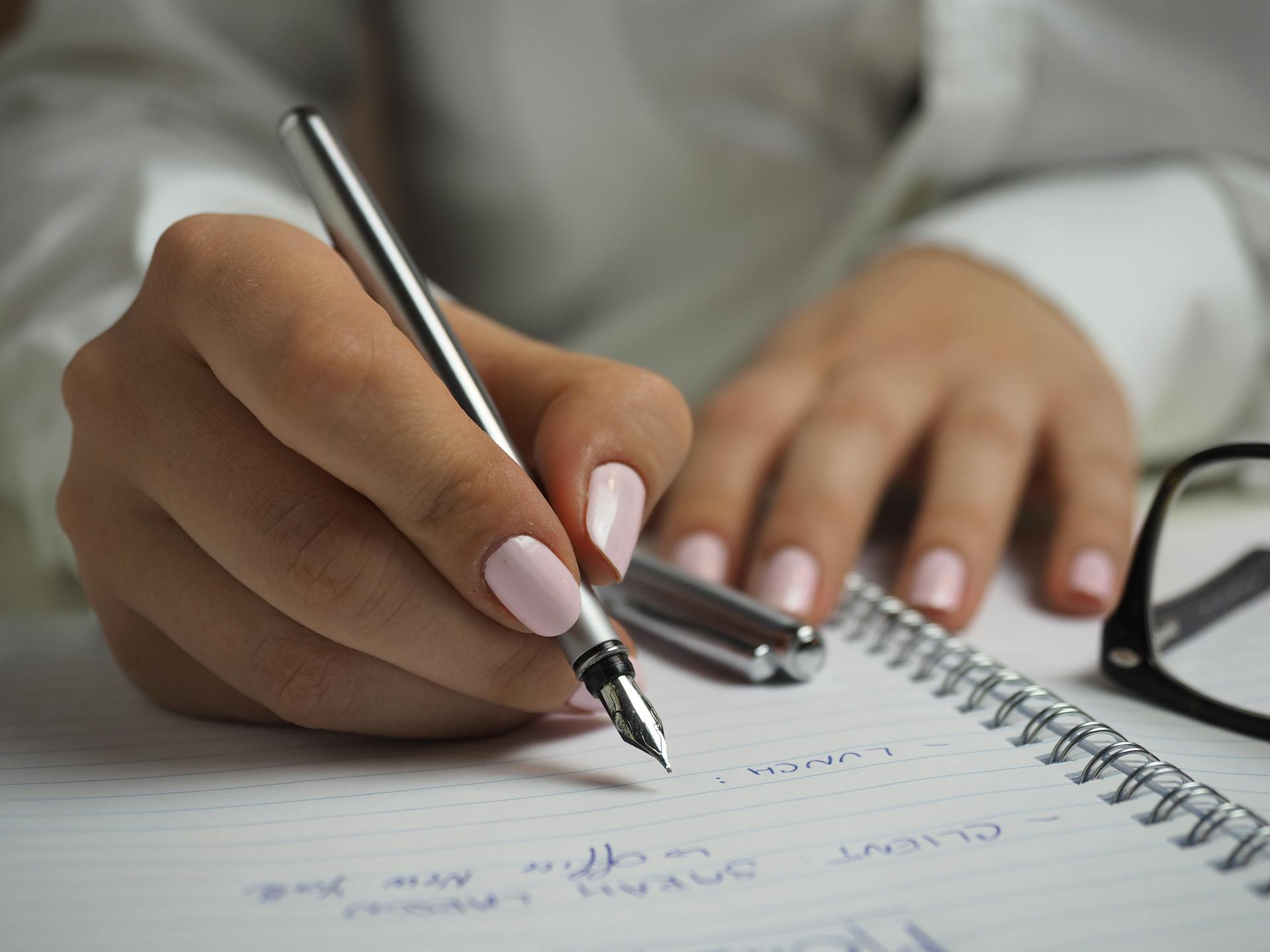A person writing in a notebook | Source: Pexels