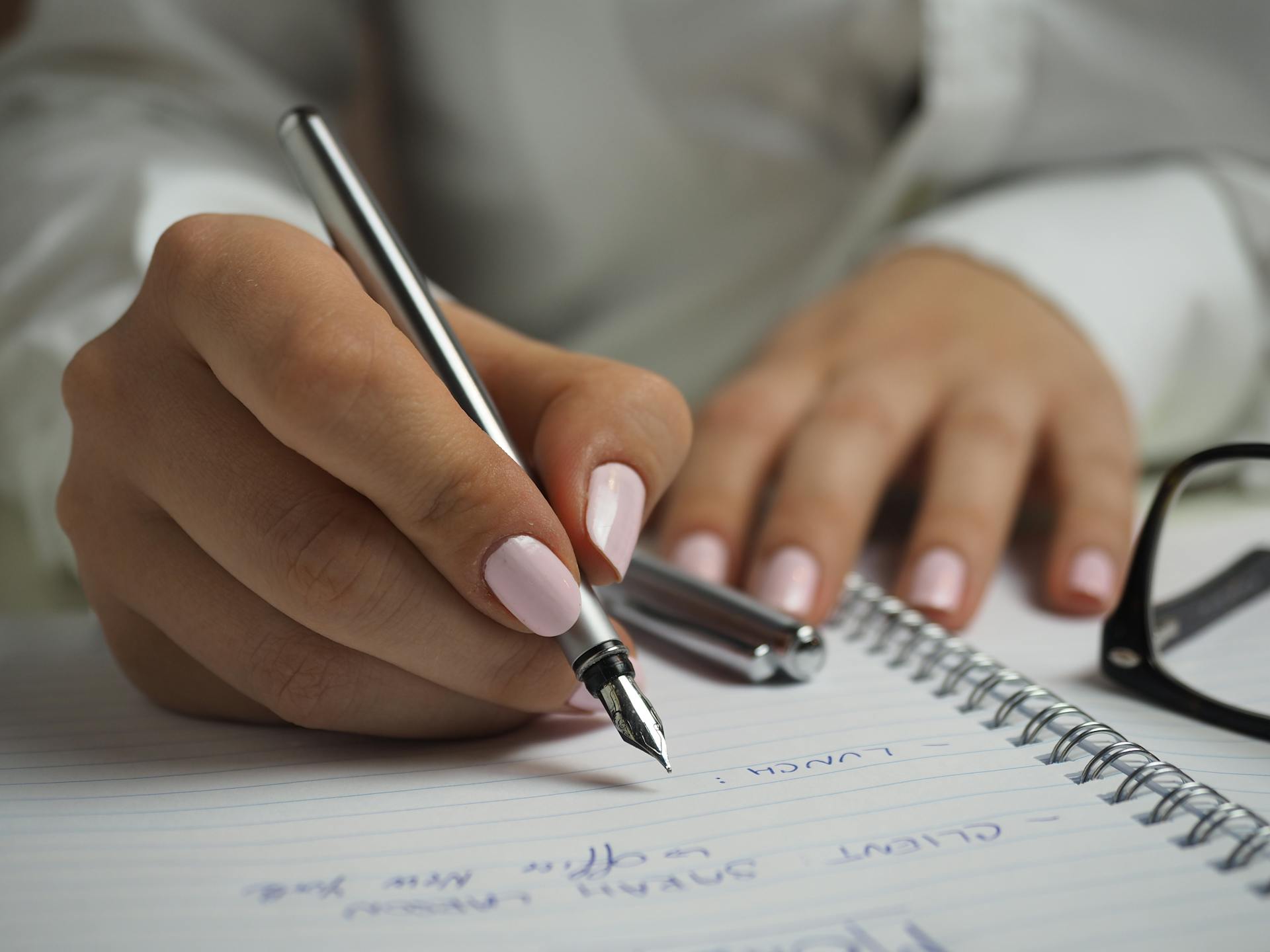 A woman writing on a notebook | Source: Pexels