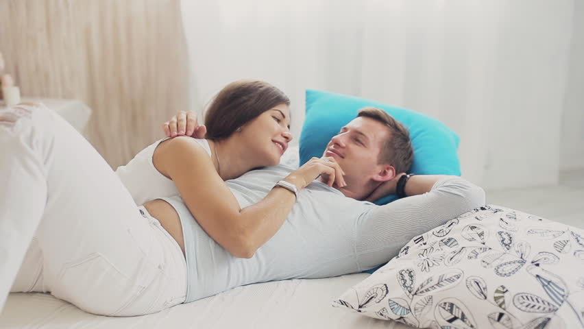 Cute couple cuddling and talking on the bed | Source: Shutterstock