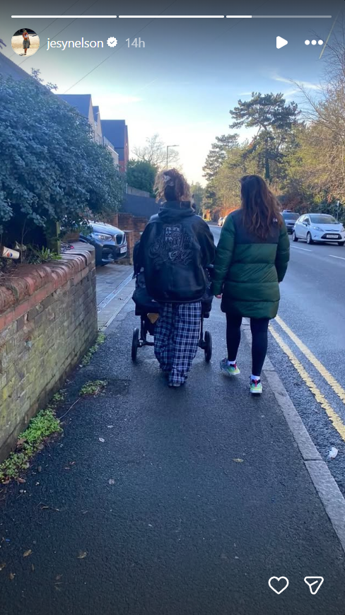 Nelson is seen from behind, wrapped up against the chill as she pushes her daughters' stroller down a quiet residential street — a loved one walking closely at her side in quiet solidarity. | Source: Instagram/jesynelson