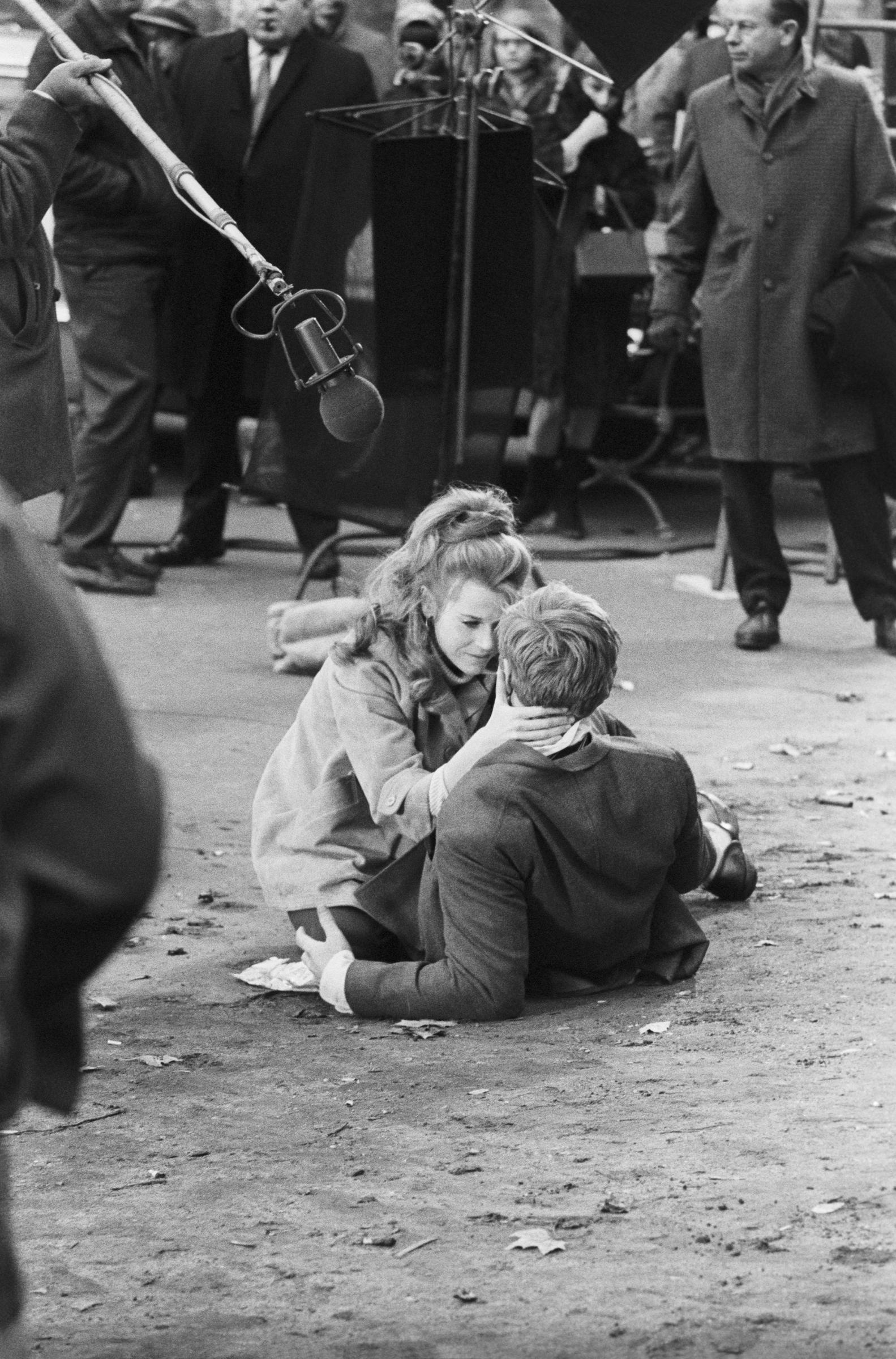Robert Redford and Jane Fonda are captured filming in Washington Square Park in New York. Redford lies on the ground as Fonda holds him by the neck, placing them in a position where they gaze into each other’s eyes.