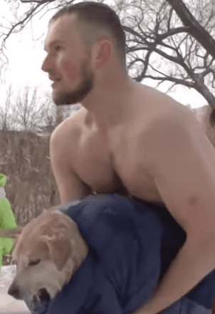 El reportero cubriendo al perro con su propia ropa. │ Foto: Captura de Facebook/Gazeta Russa