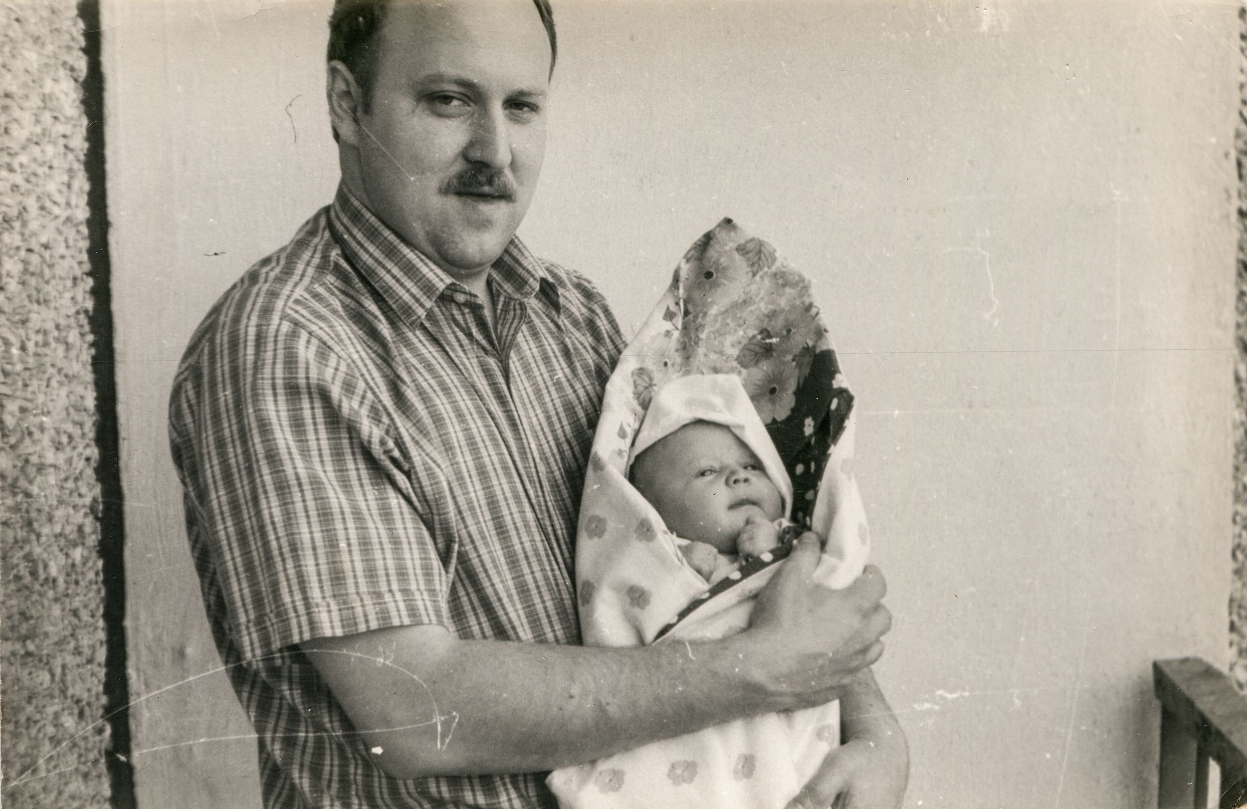 Old photograph of a man holding a baby. | Source: Shutterstock