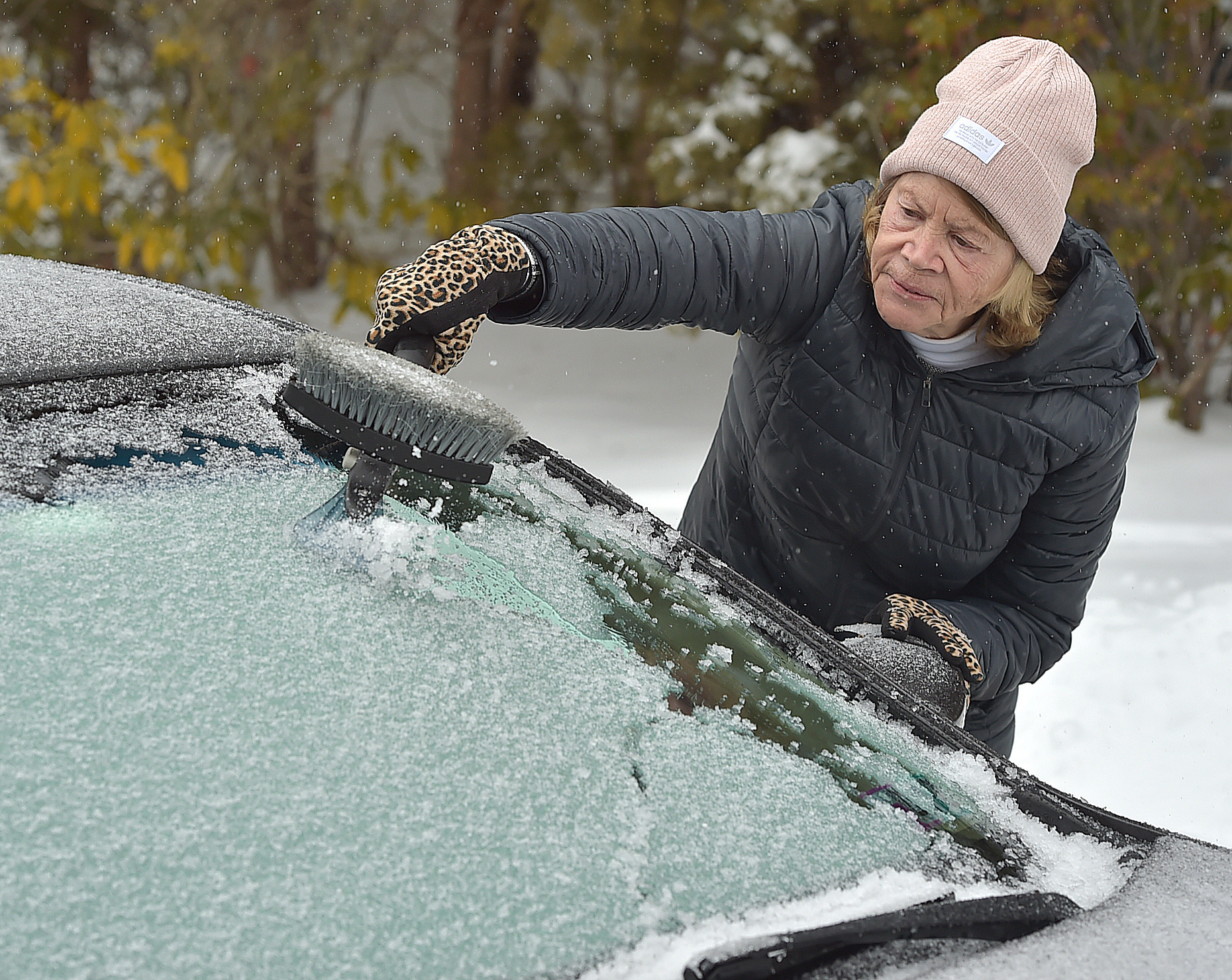 A woman clears ice from her car windshield | Source: Getty Images