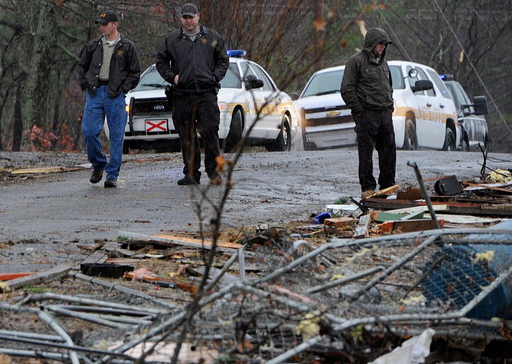 DeKalb County Sheriff's Deputies stand watch next to a log home which was destroyed by a tornado in the early morning hours on November 30, 2016 | Photo: Getty Images