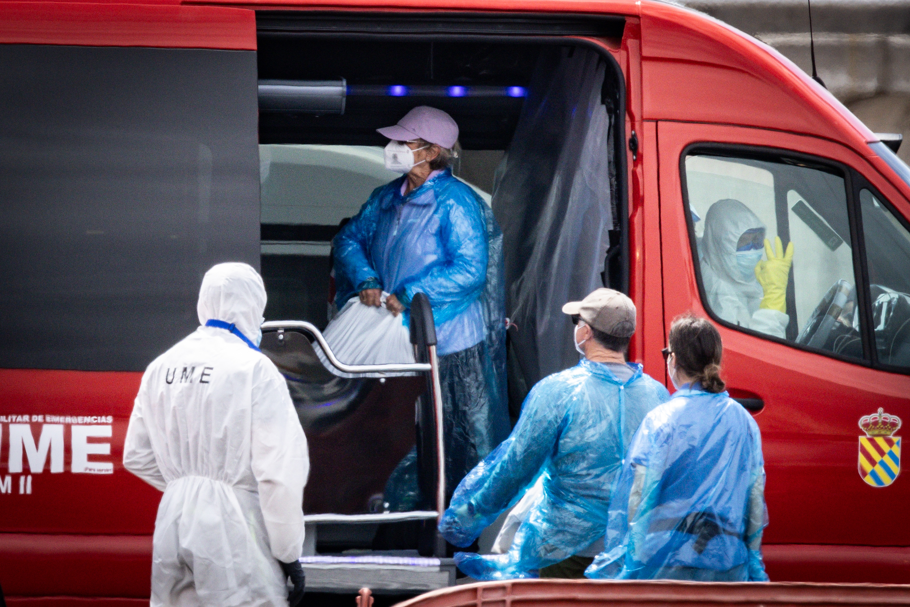 A passenger carries their belongings in a plastic bag to a waiting bus after being evacuated from the MV Hondius after docking in the Granadilla Port on May 10, 2026 in Tenerife, part of the Canary Islands, Spain. | Source: Getty Images
