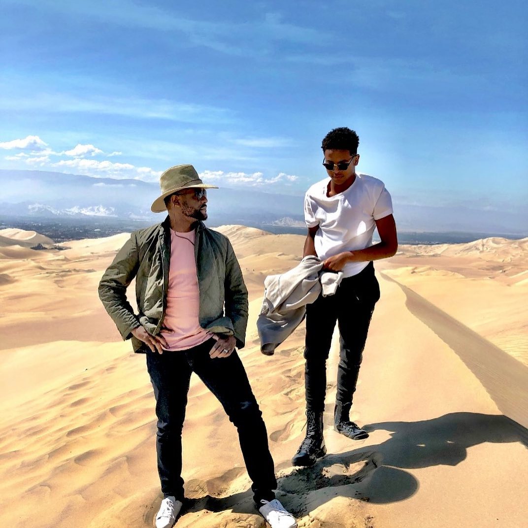 Blake Underwood walks alongside Blair Underwood across scenic sand dunes, sharing a quiet father-son moment against a sweeping desert backdrop. | Source: Instagram/blairunderwood_official