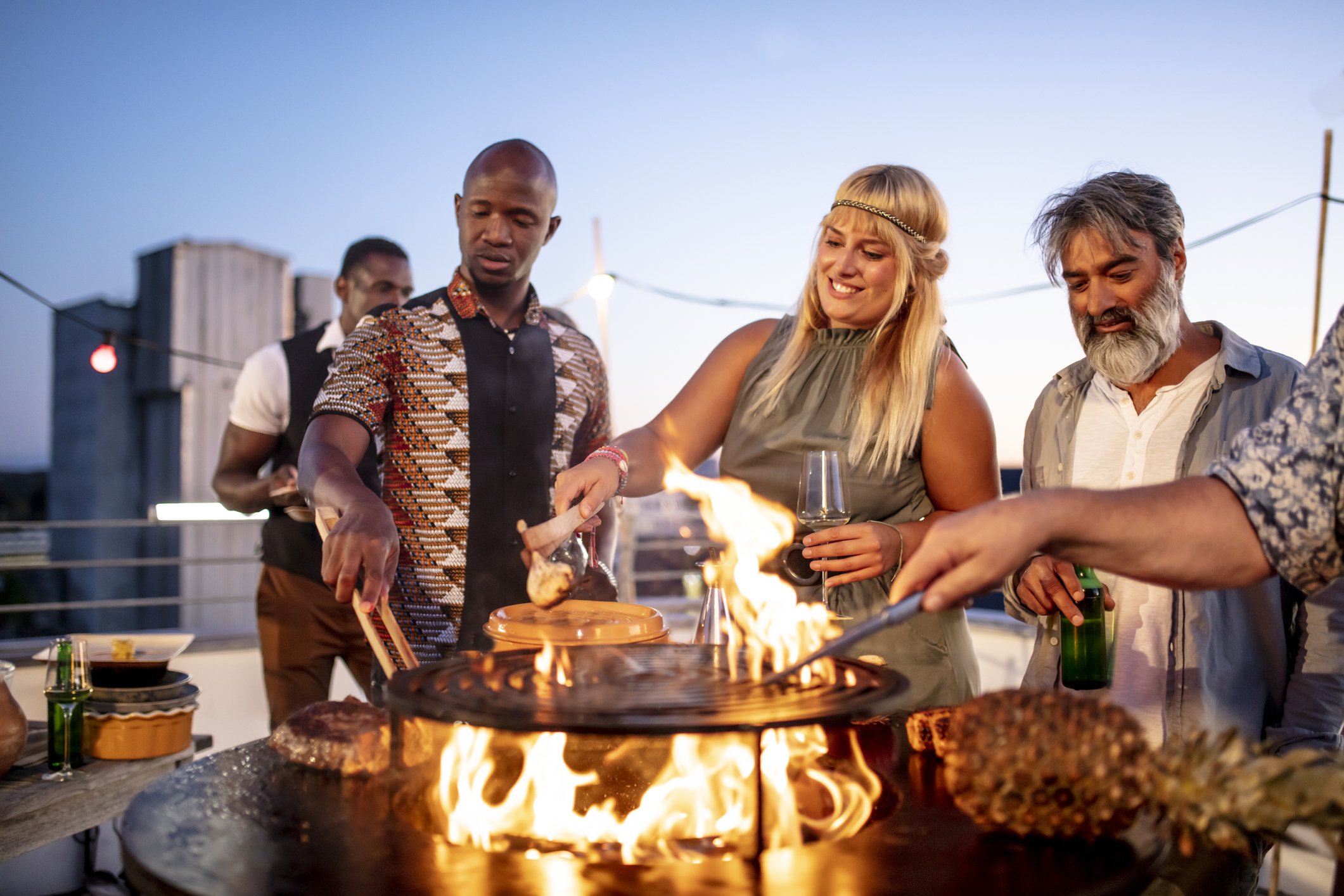 Picture of a group of people braaing together at a party. | Photo: Getty Images