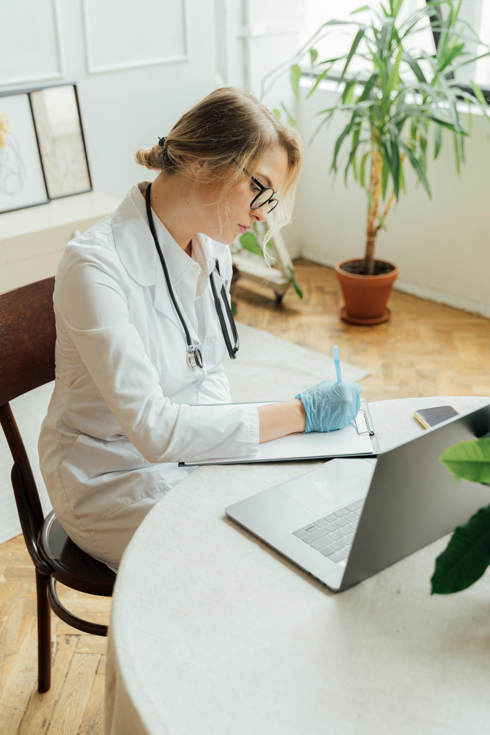 A female doctor writing on a clipboard | Source: Pexels