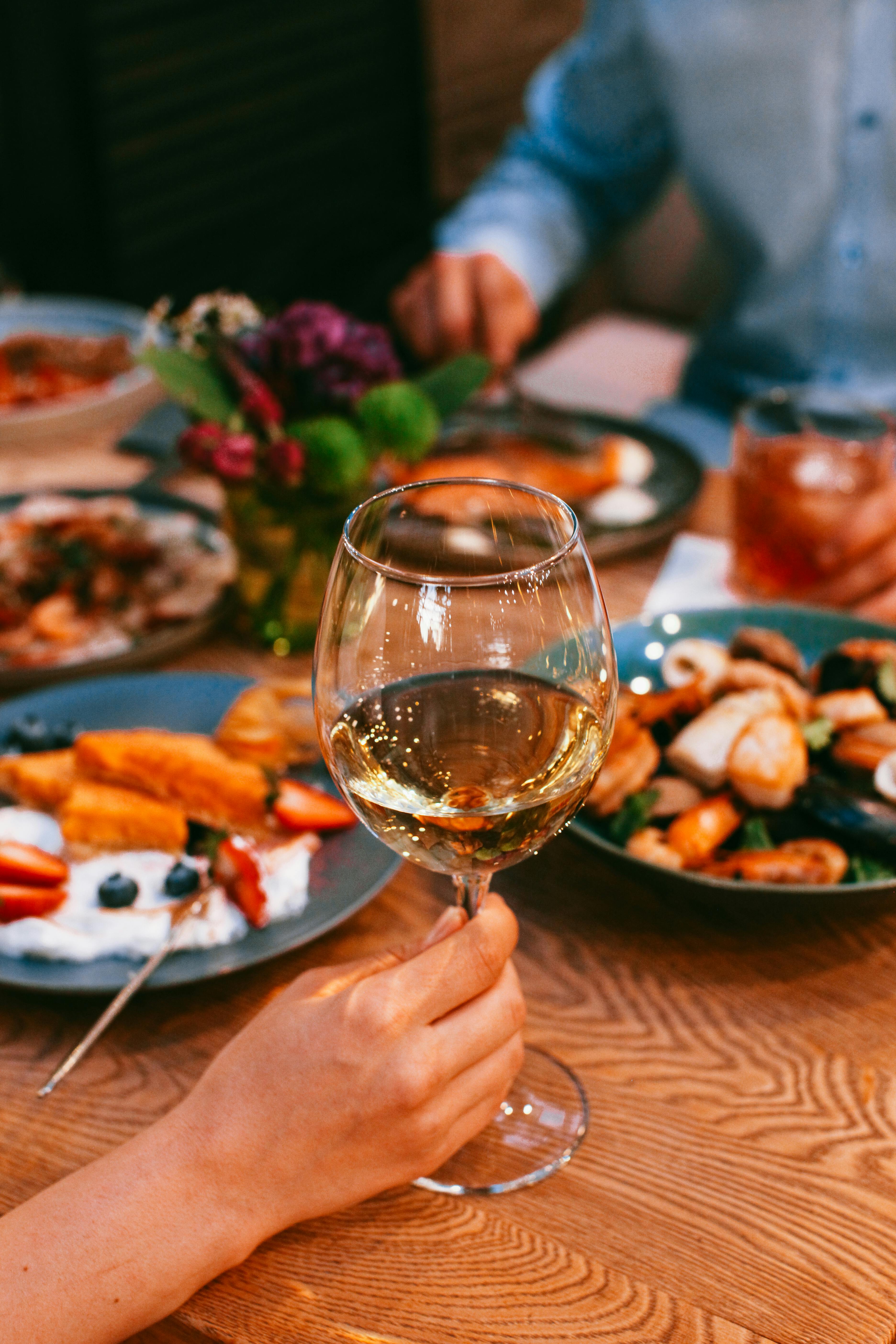 Someone holding a glass during a meal | Source: Pexels