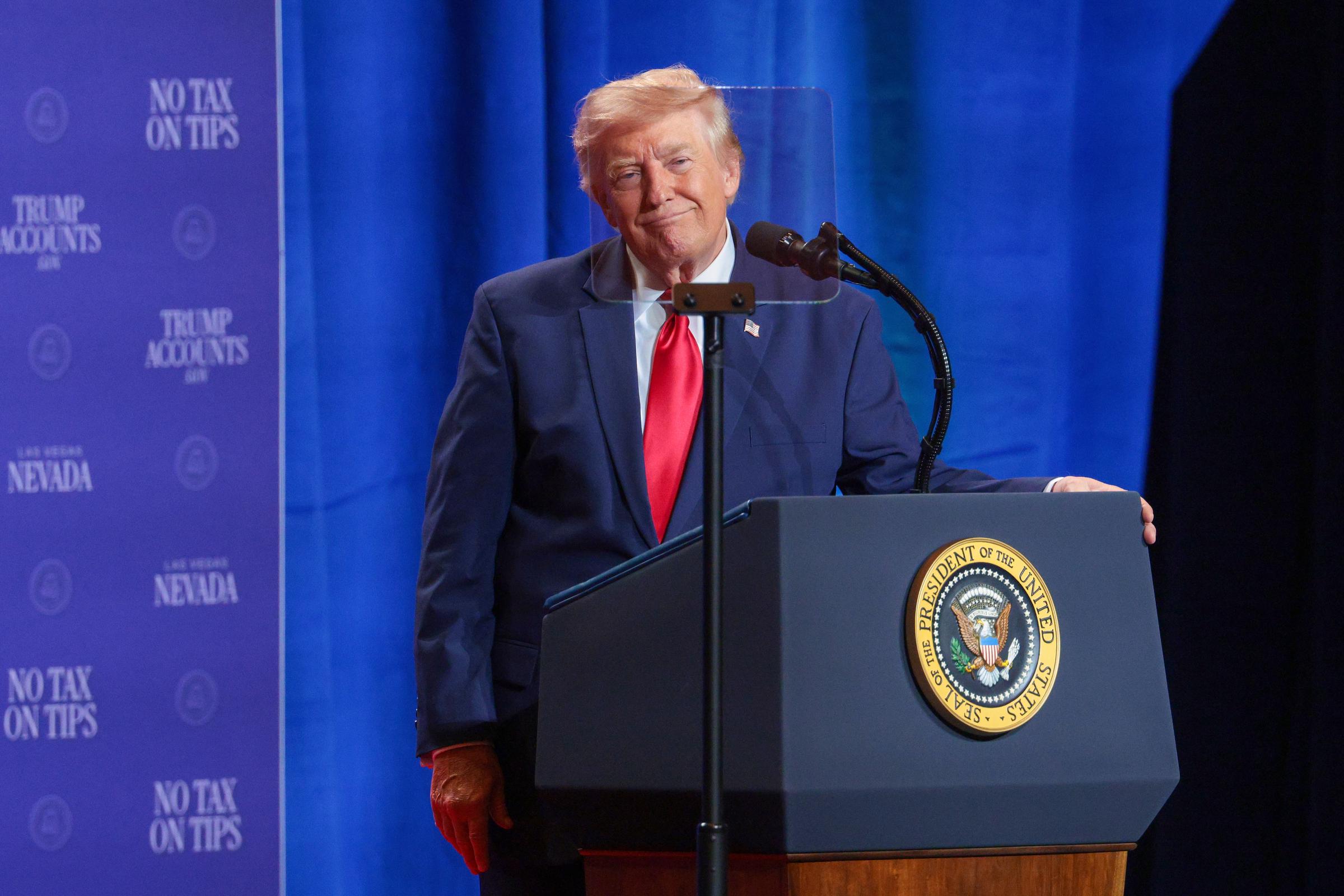At the Las Vegas event, Trump’s hair appeared fuller at the front, with longer blond strands swept across the top and more lift than in recent photos. The frontal angle made the added volume especially noticeable as he stood behind the lectern. | Source: Getty Images