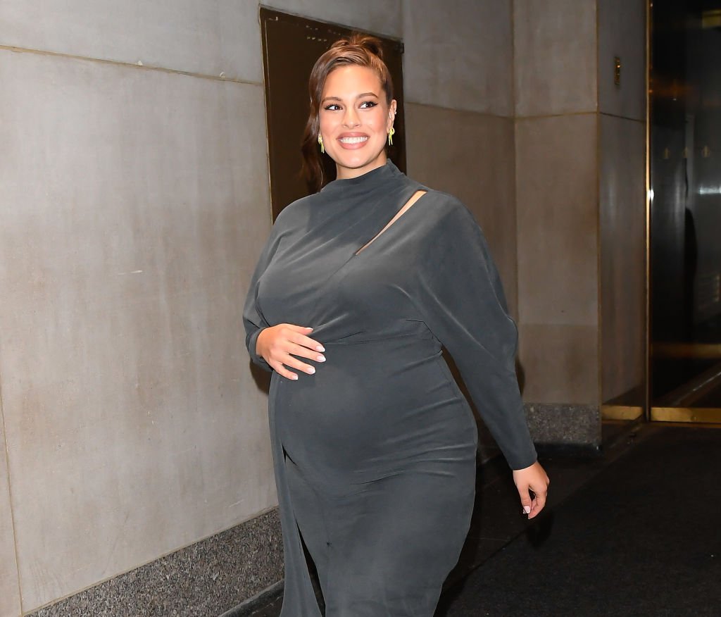 Ashley Graham cradles her pregnant belly as she seen leaving outside the "Today" show, on October 30, 2019, New York | Source: Getty Images (Photo by Raymond Hall/GC Images)